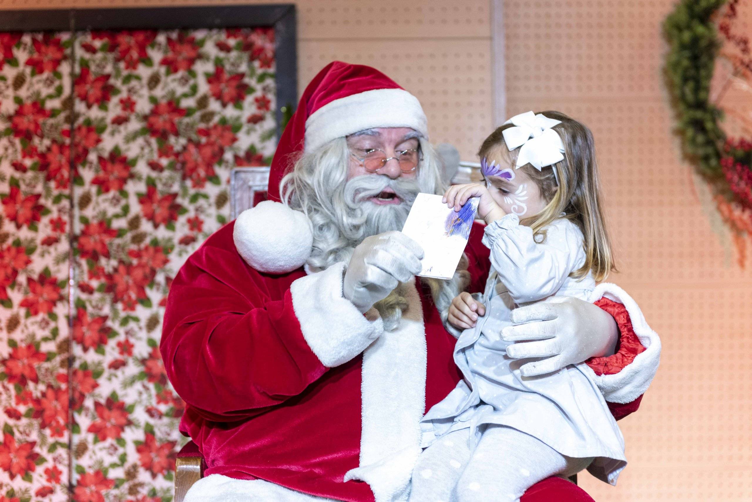 Papá Noel con una de las niñas asistentes.
