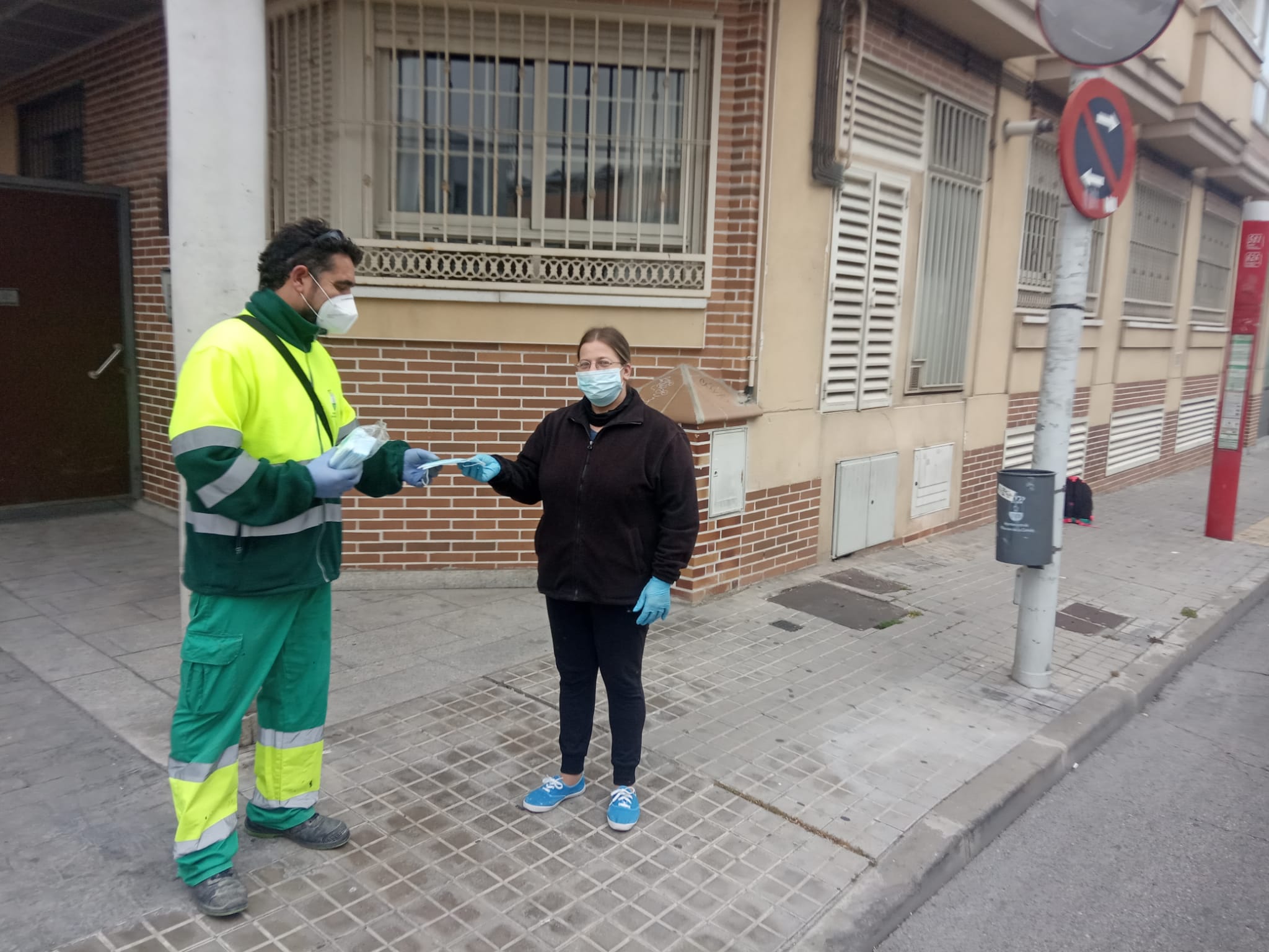 Uno de los operarios entregando una mascarilla.