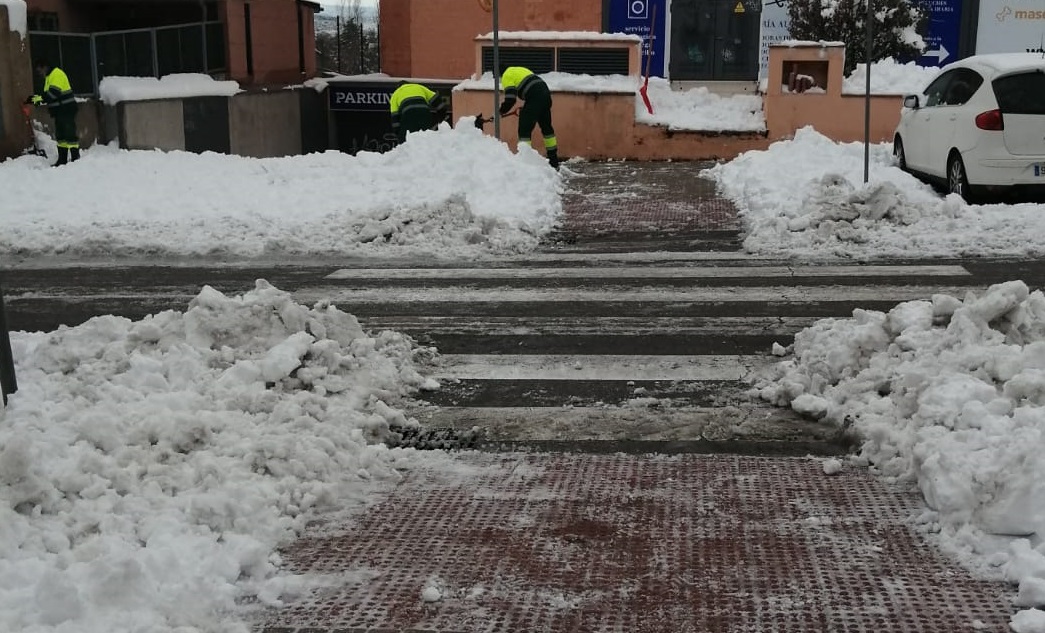 Operarios municipales retirando nieve de pasos de peatones.