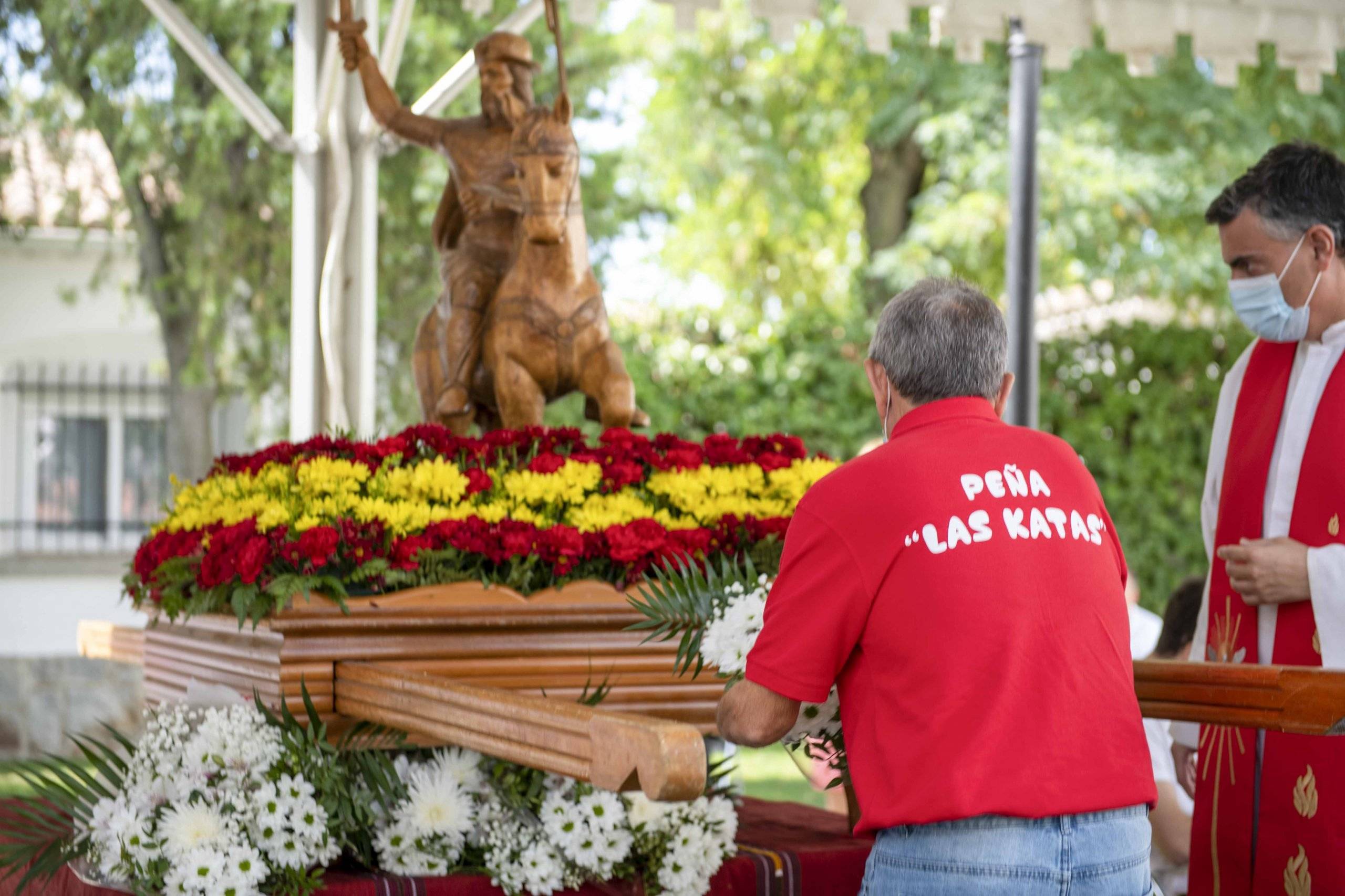 Un representante de la peña Las Katas depositando ante la talla del santo un ramo de flores.