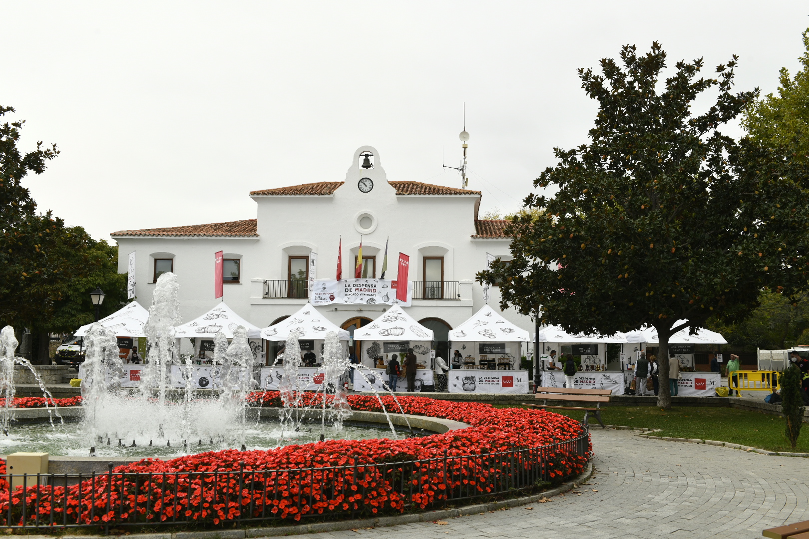 Imagen de la fuente de la plaza de España y puestos del mercado itinerante.