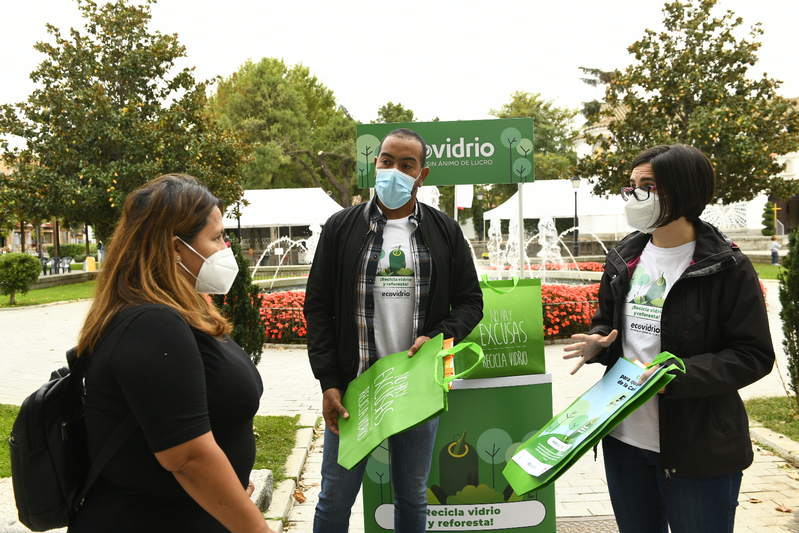 Los educadores de Ecovidrio informando a una vecina sobre la campaña..