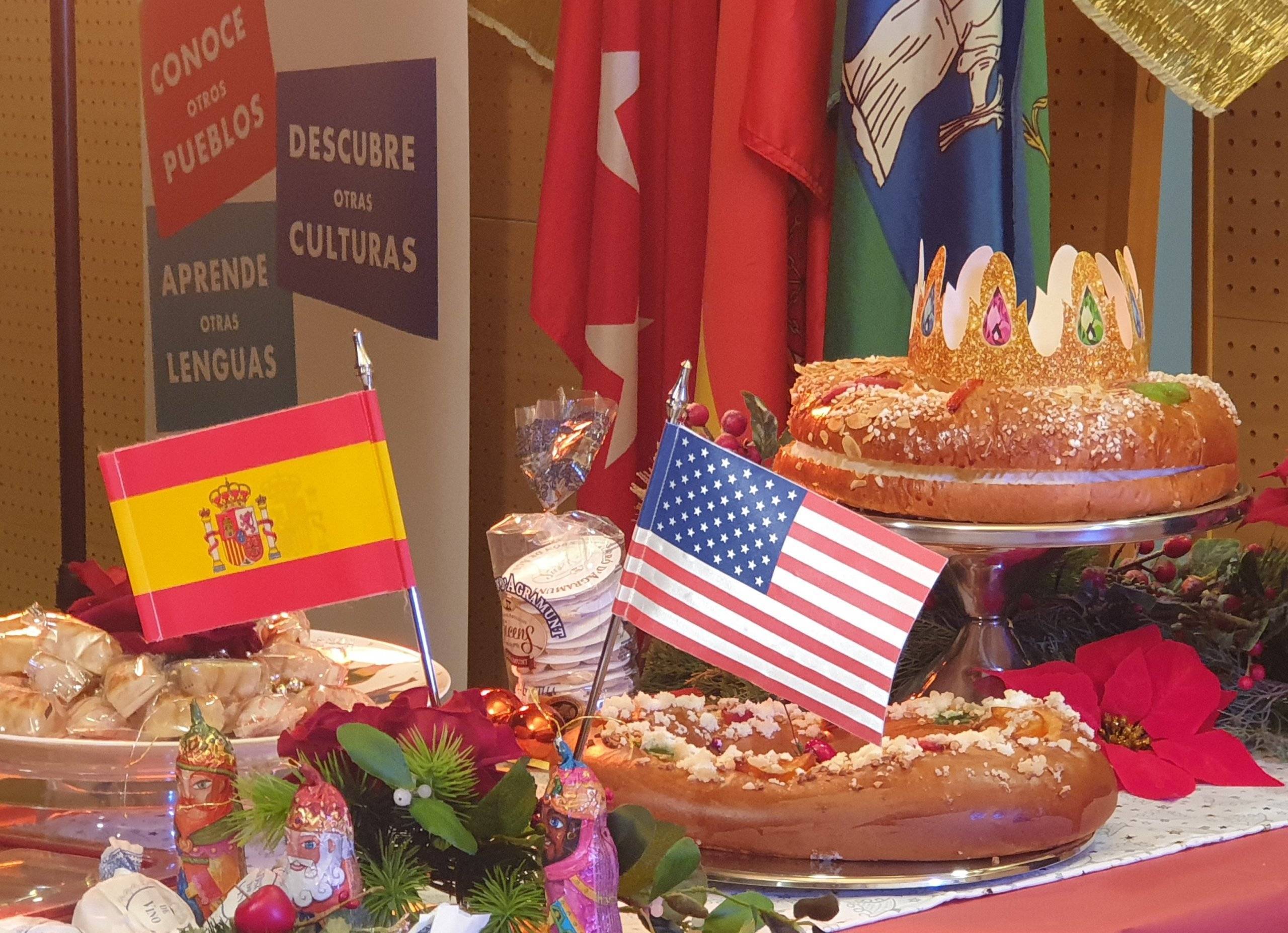 Roscones de reyes y mazapán sobre una mesa con banderas de España y EEUU.