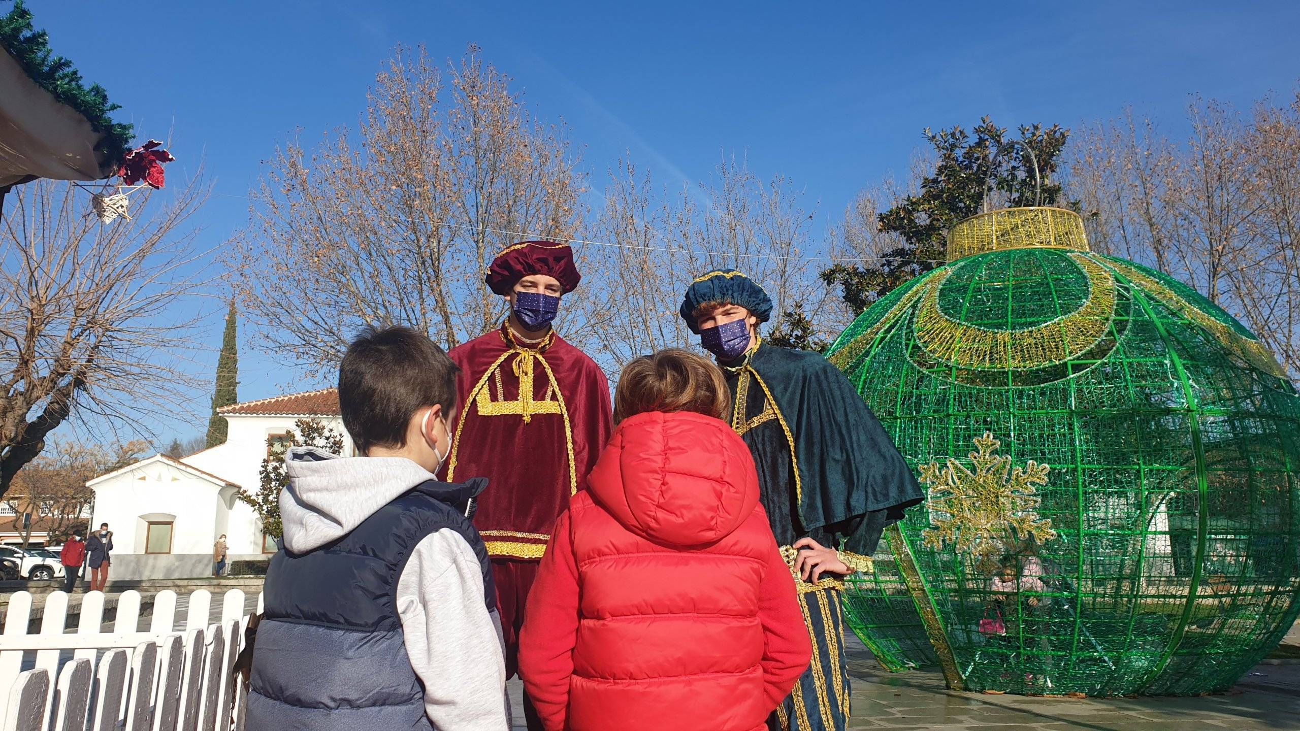 Los pajes reales saludando a dos niños.