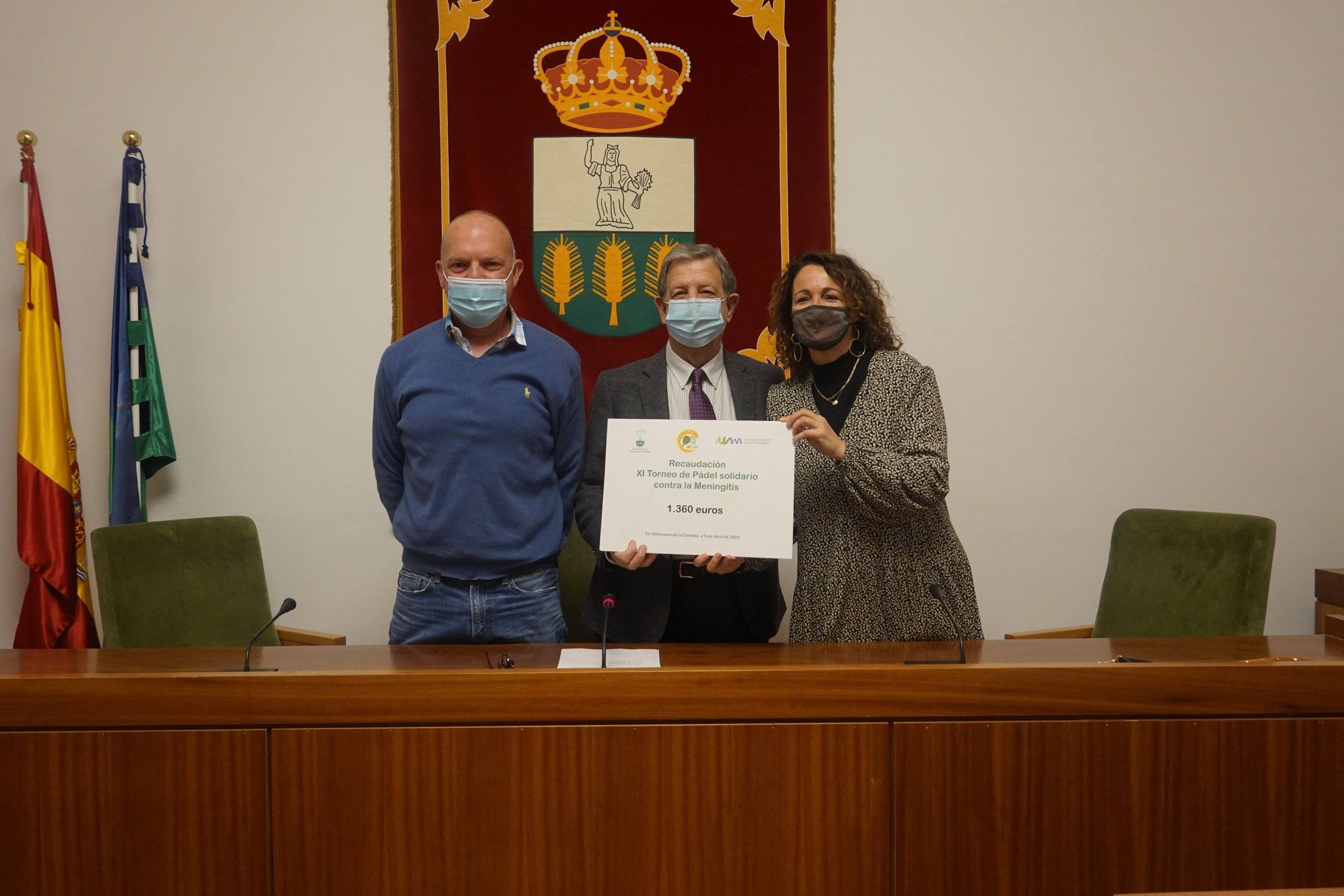 El alcalde, Luis Partida, y el presidente del Club de Tenis y Pádel de Villanueva de la Cañada, Tomás de Prada, en el acto de entrega del cheque a la vicepresidenta de la Asociación Española contra la Meningitis, Elena Moya.