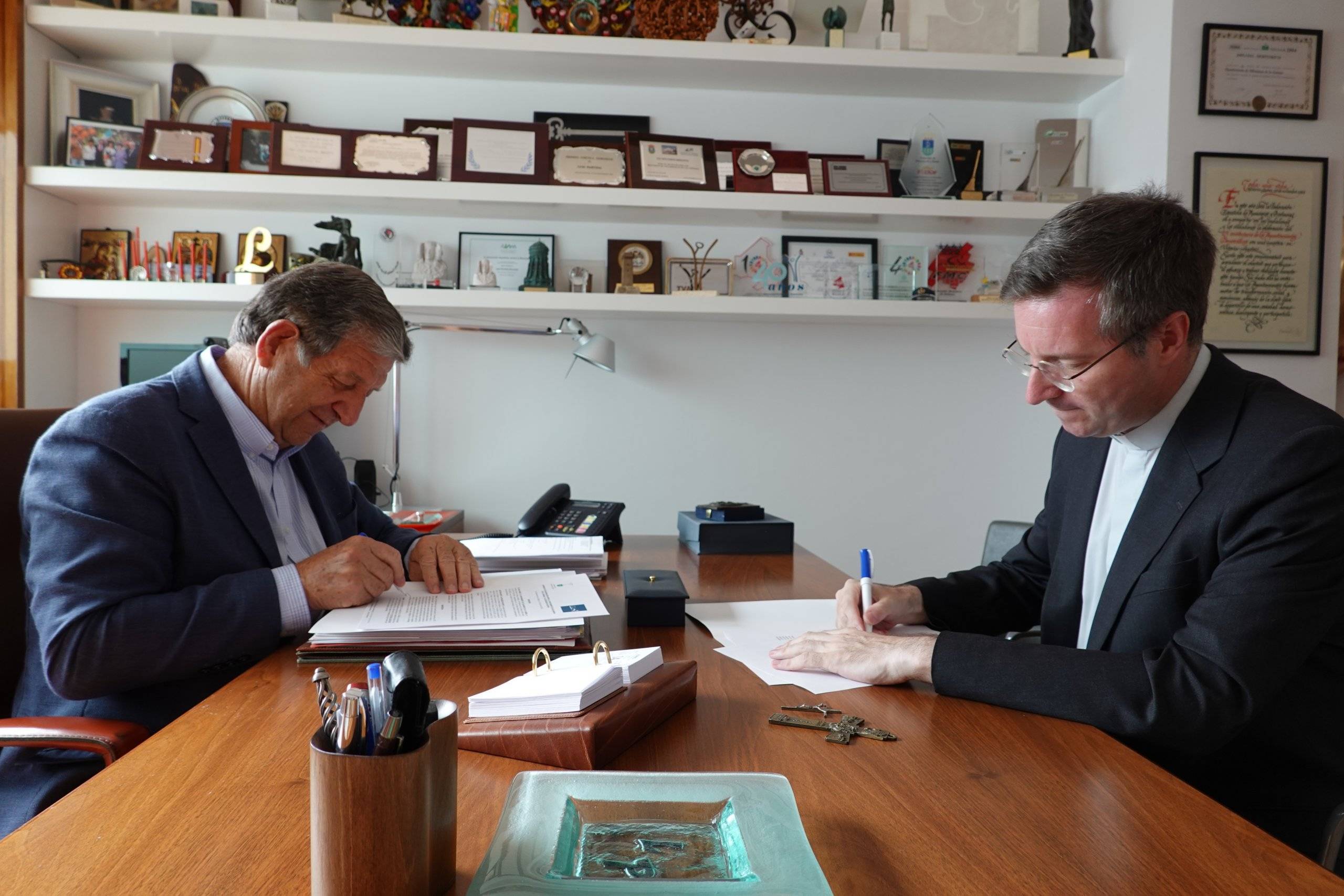 El alcalde firmando el convenio junto con el vicario de la Diócesis de Getafe, Francisco Javier Mairata de Anduiza.