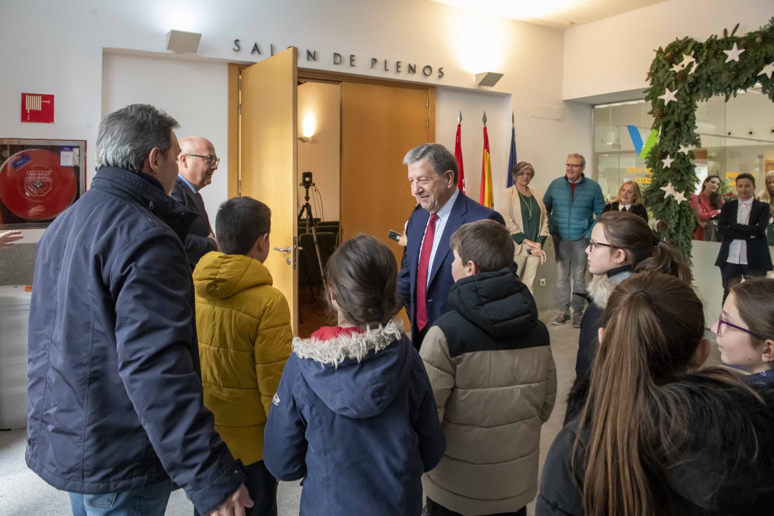 El alcalde recibiendo a un grupo de escolares participantes antes del inicio de la sesión.