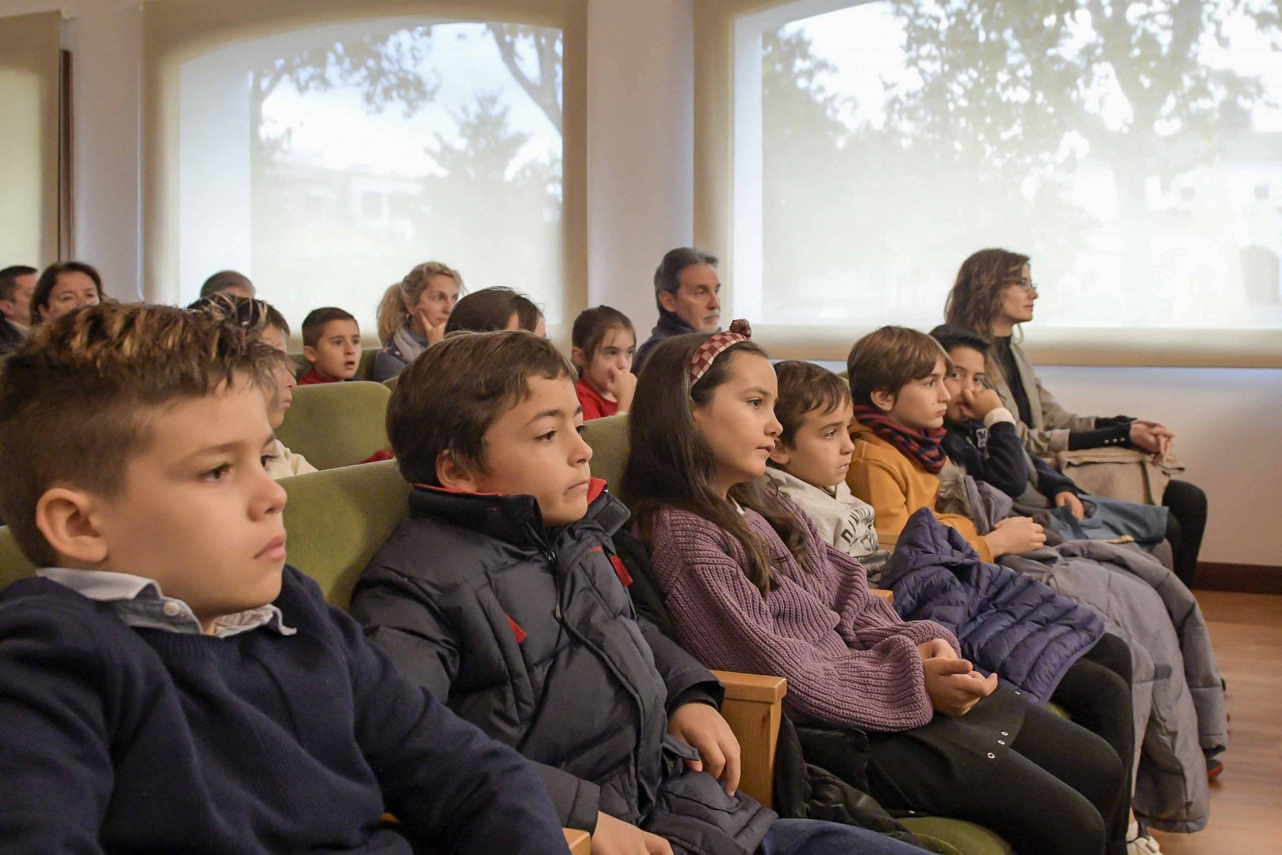 Escolares siguiendo el pleno entre el público.