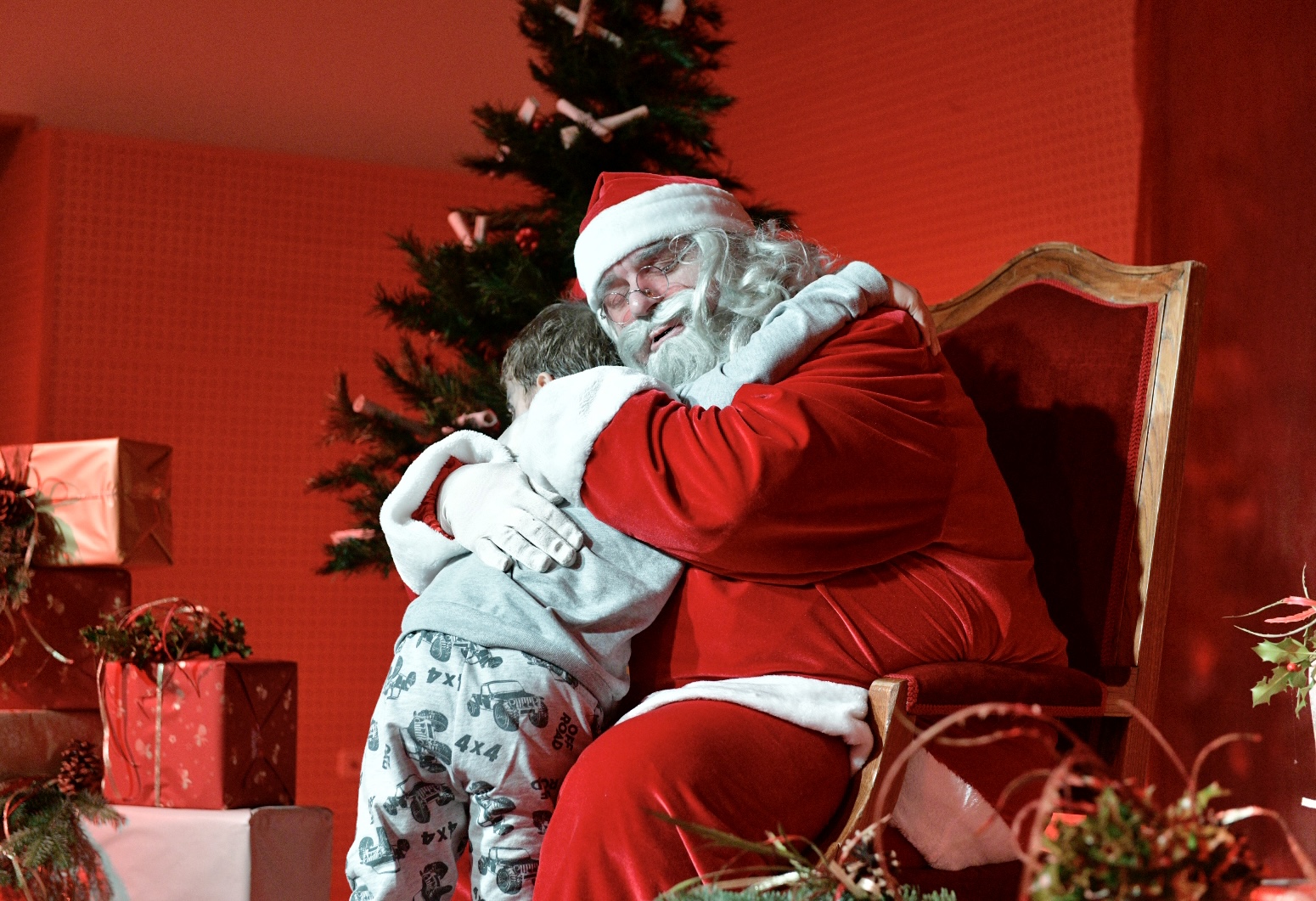 Papá Noel abraza a uno de los niños asistentes.