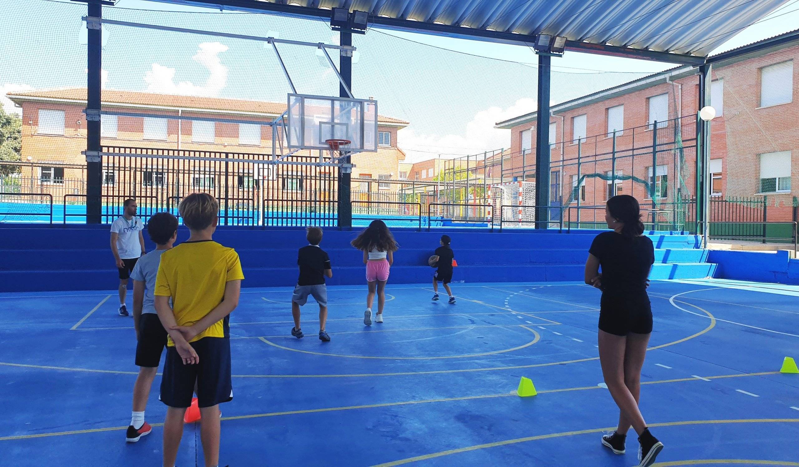 Niños participantes en el Minicampus de verano jugando al baloncesto.