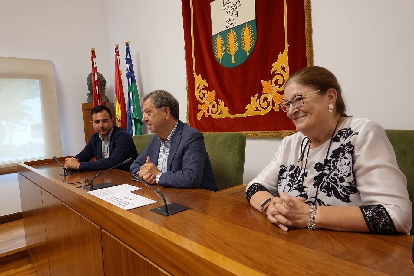 El alcalde, durante su intervención, junto a la coordinadora de Cáritas y concejal de festejos.