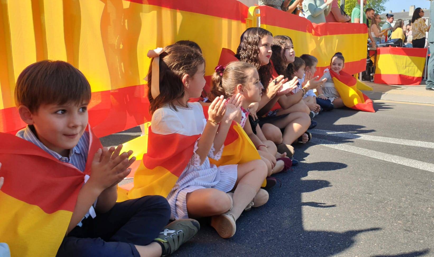 Niños con la bandera de España durante el acto institucional.