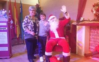 Papá Noel saluda junto a una abuela y su nieto.