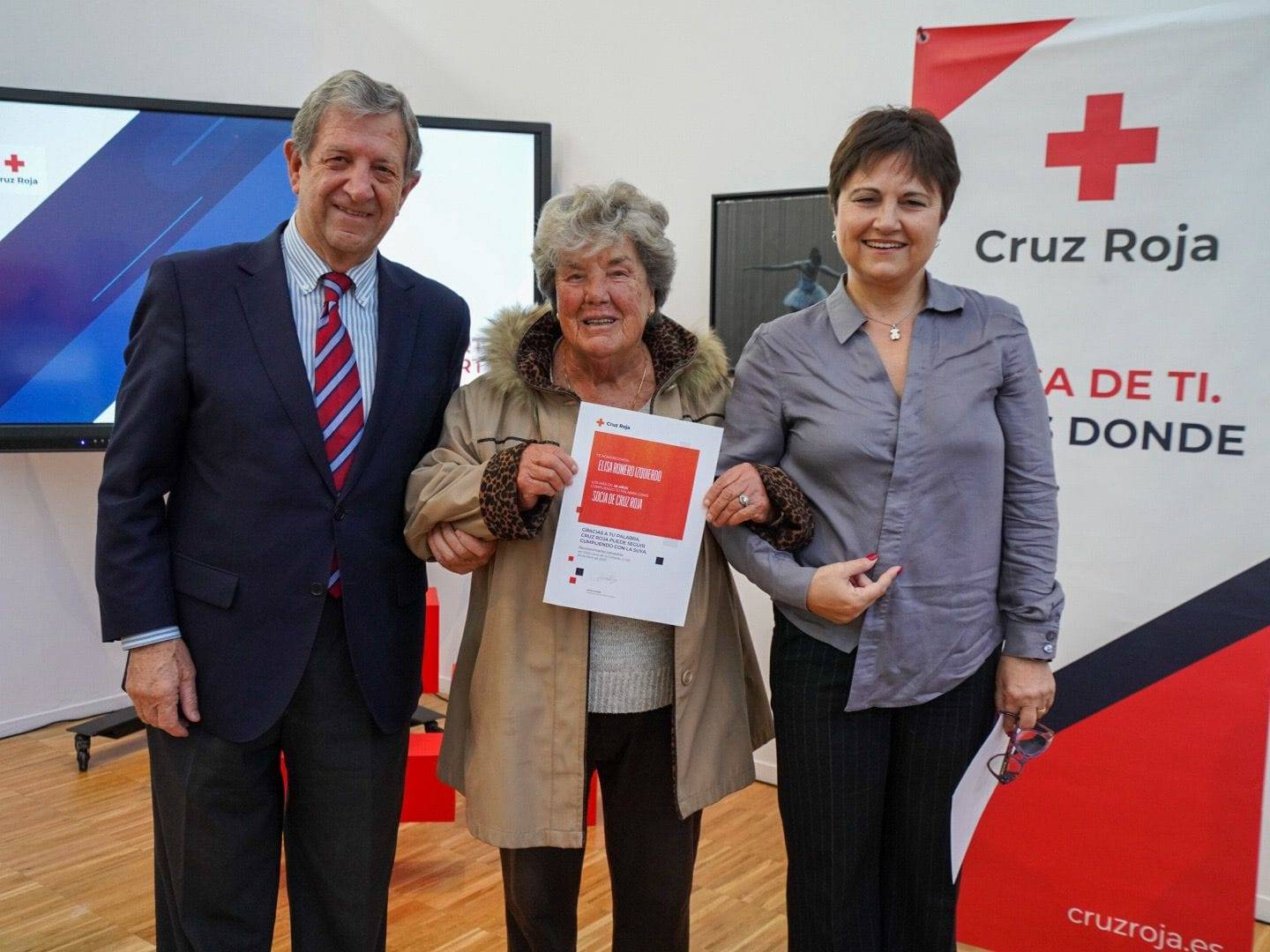 El alcalde y la directora comarcal entregando reconocimiento a una socia de Cruz Roja.