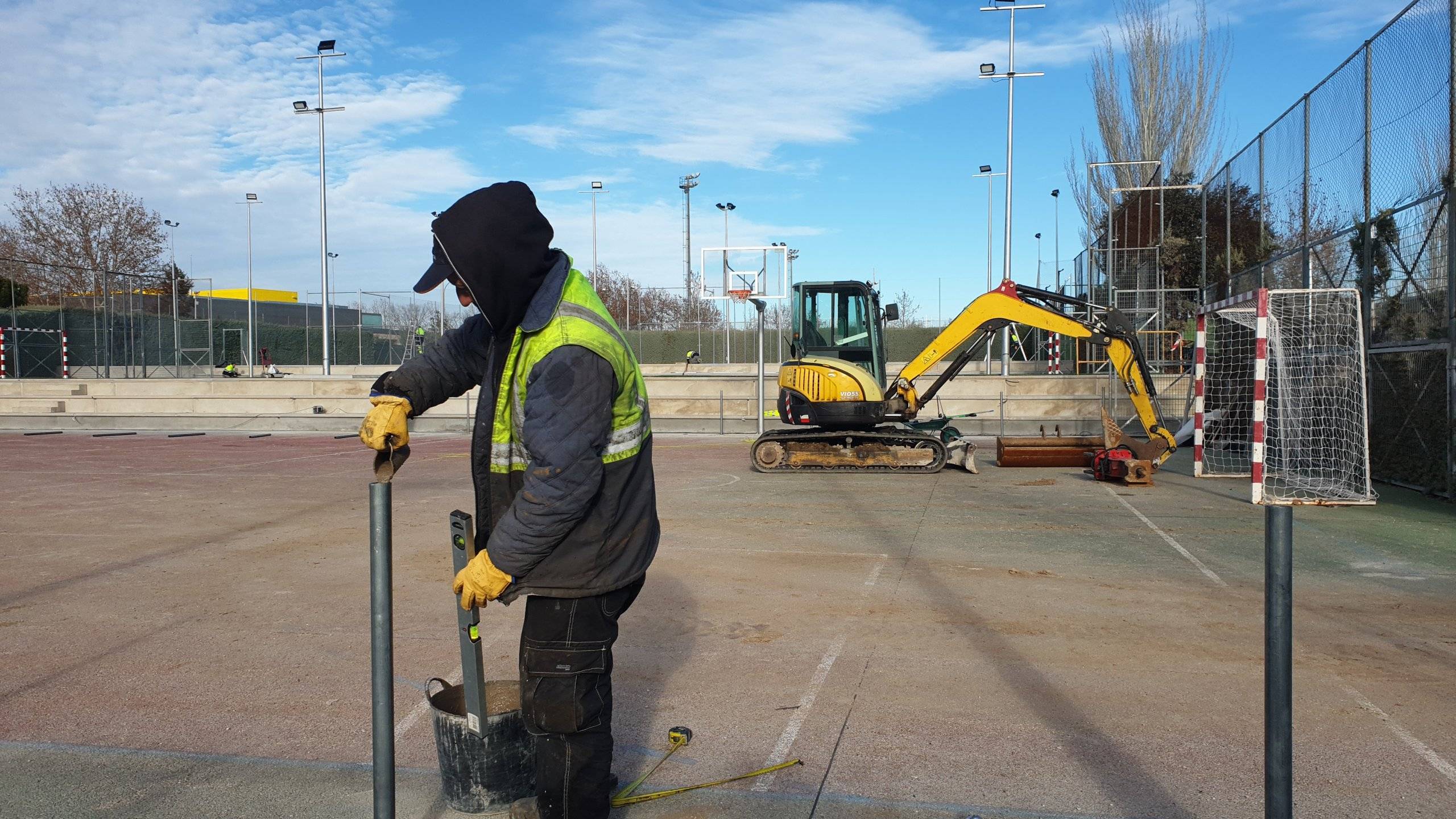 Trabajador realizando labores de vallado en las pistas deportivas.