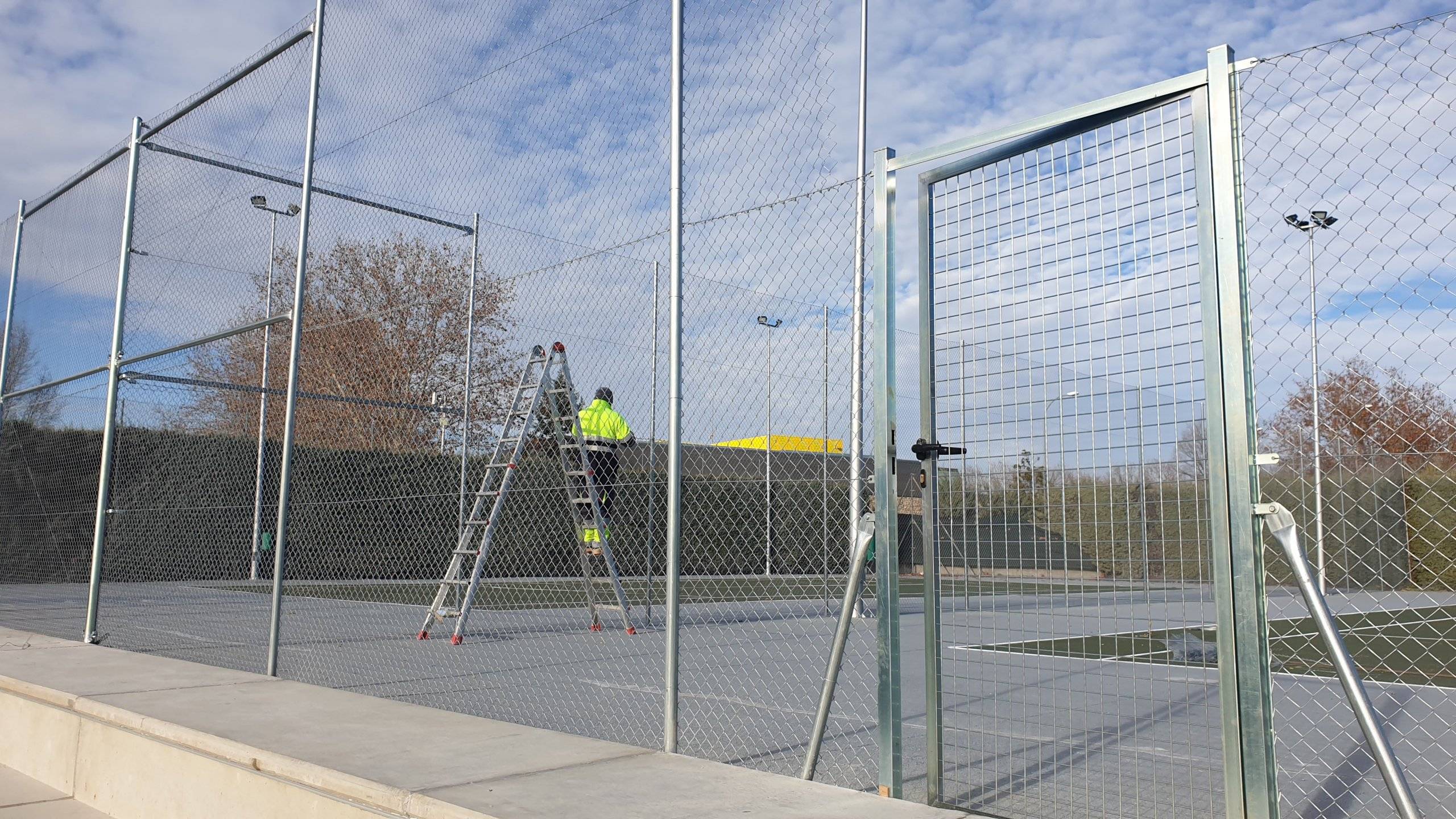 Trabajador realizando labores de rehabilitación de las pistas de tenis.