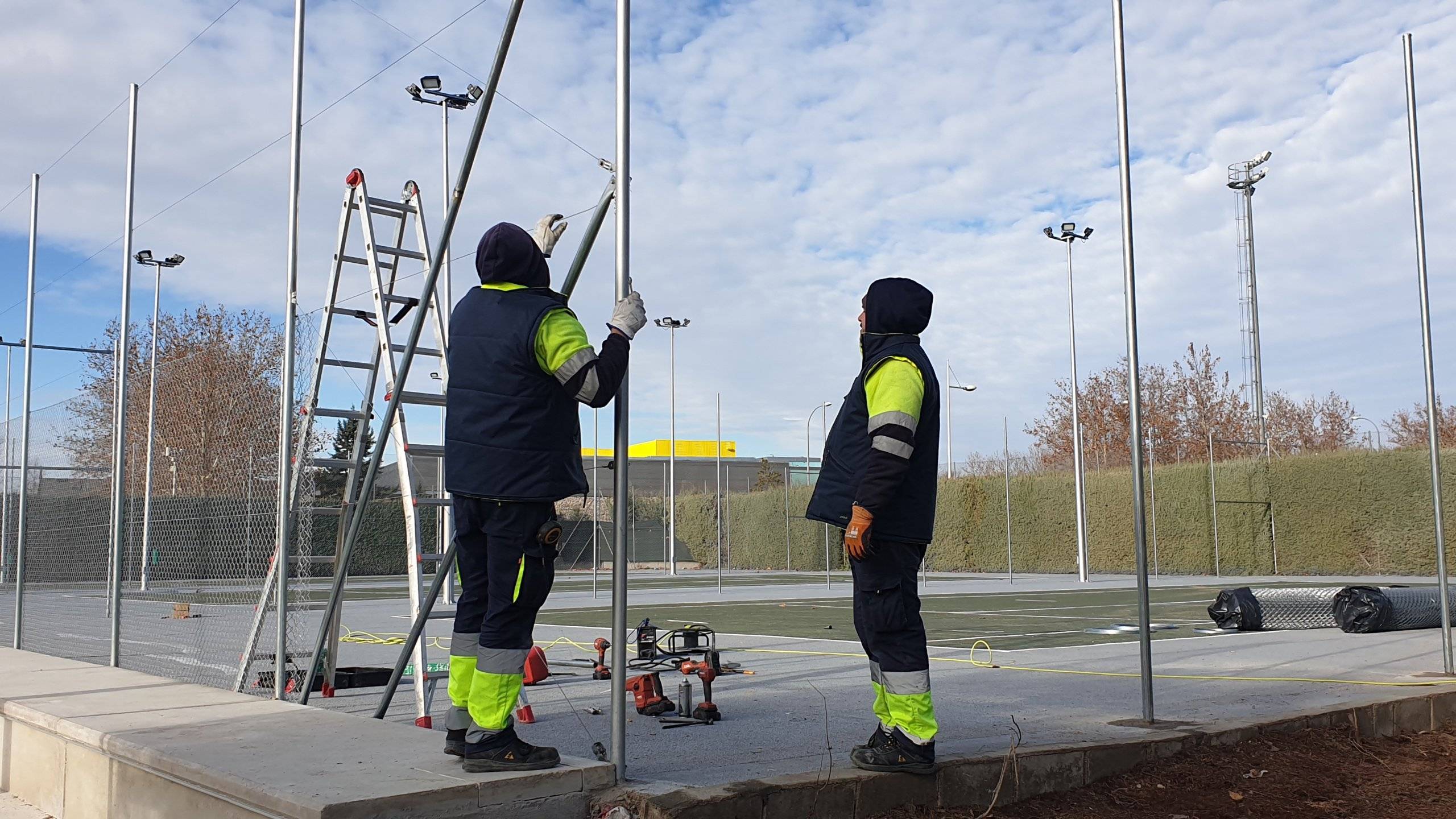 Trabajadores realizando labores de vallado de las pistas de tenis.