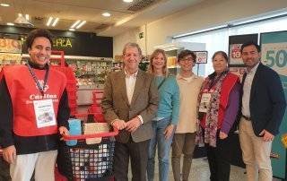 Foto de familia de autoridades y voluntarios durante la recogida de leche.