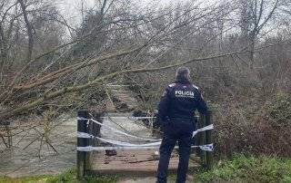 Policía Local delante de uno de los puentes de uno de los ríos desbordados.