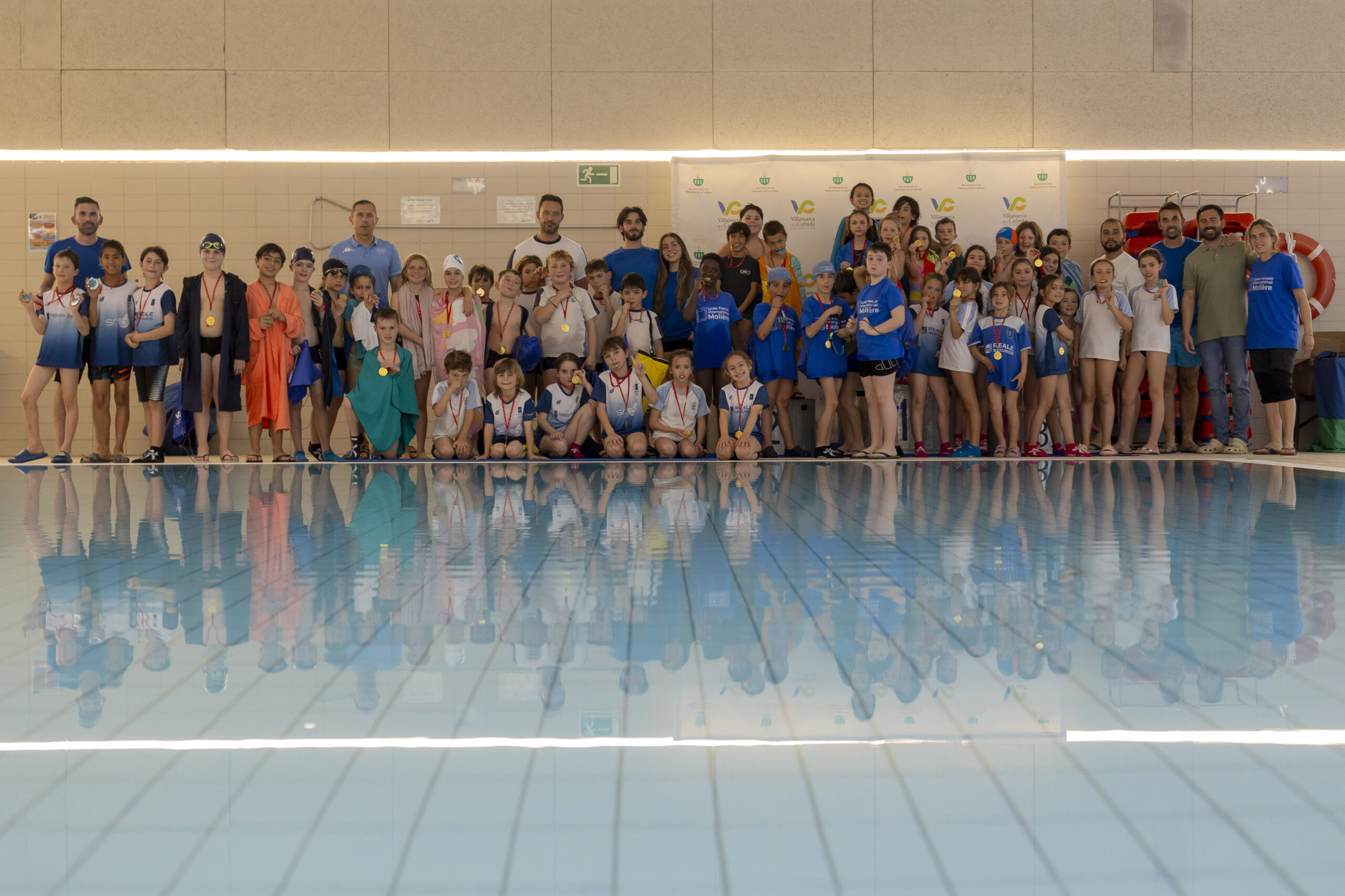 Foto de grupo de los participantes en el primer turno de la competición de natación.