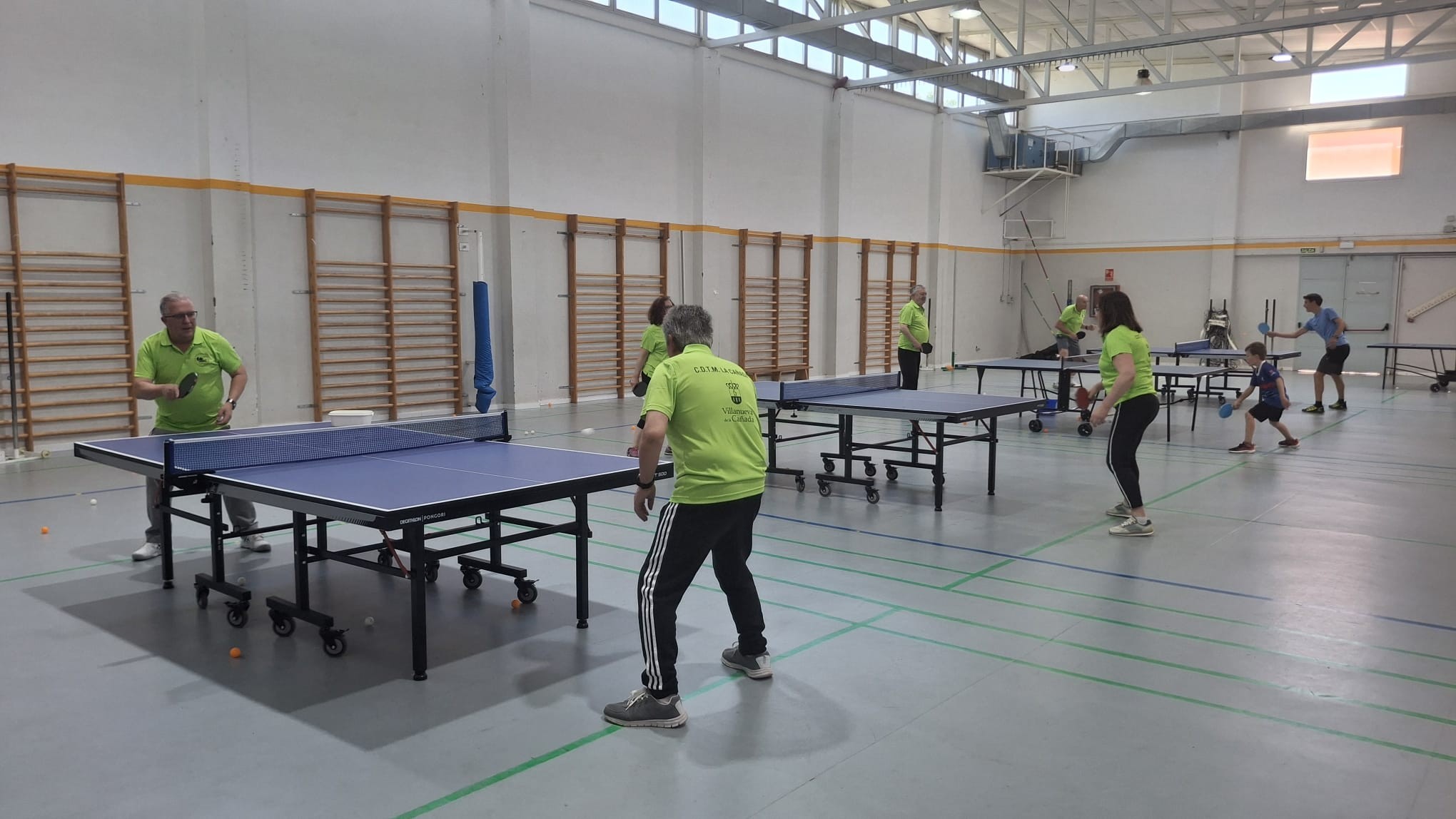 Grupo de participantes en el Día del Deporte practicando tenis de mesa.
