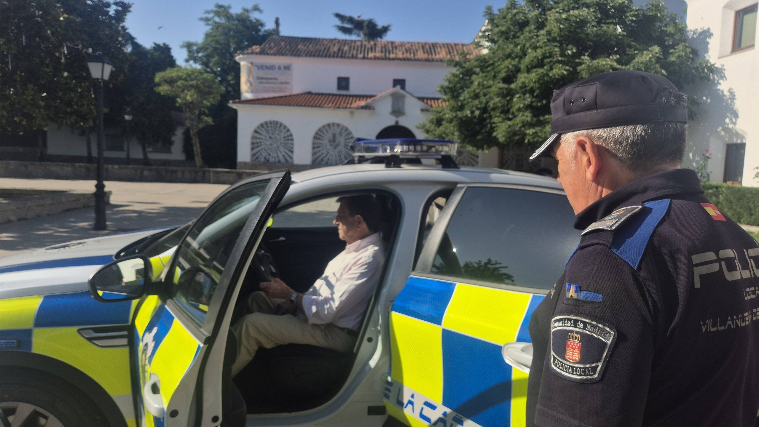 El alcalde sentado en el nuevo coche policial ante la mirada del jefe de la Policía Local.