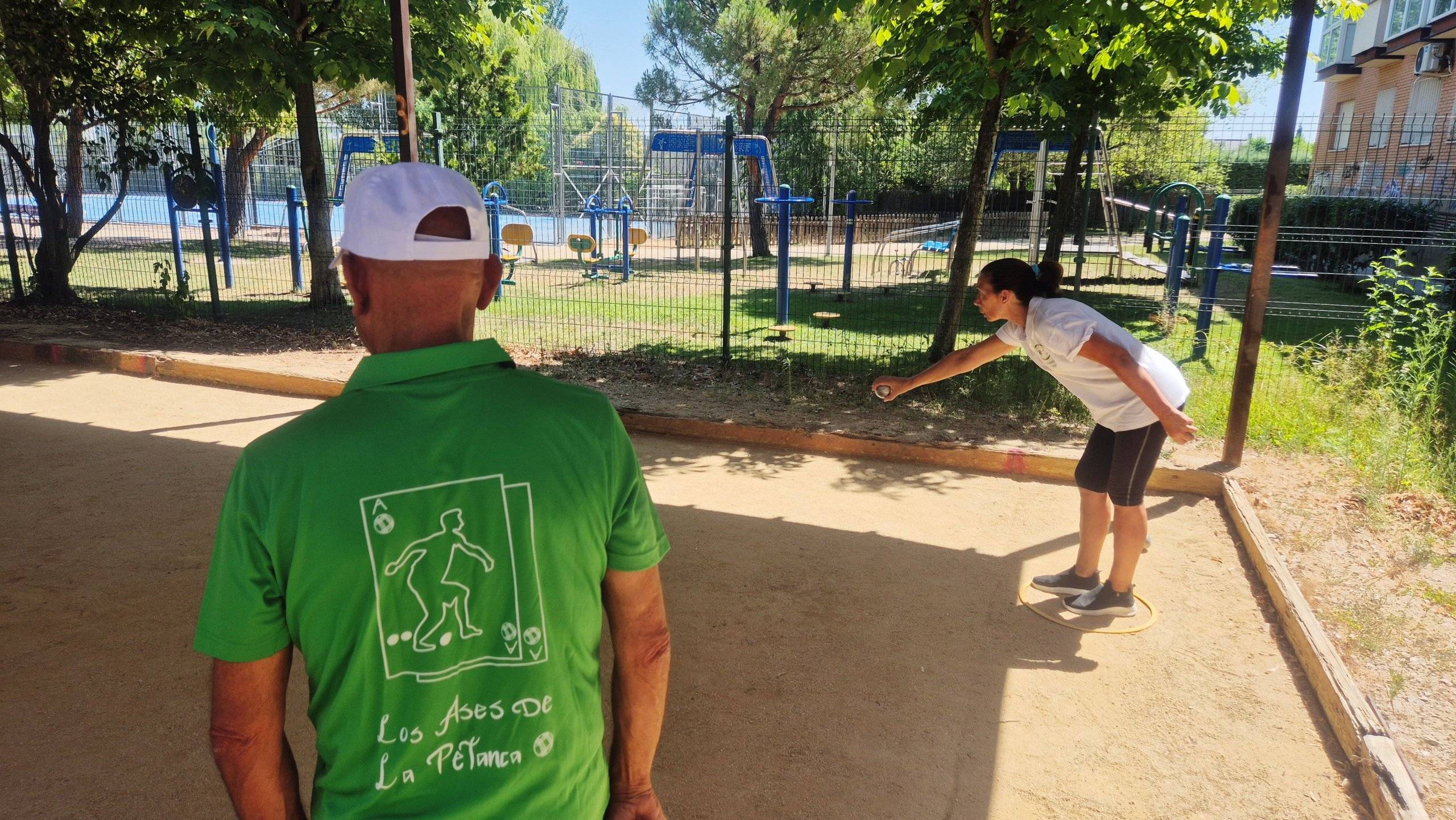 Una participante lanza una bola en presencia de otro jugador.