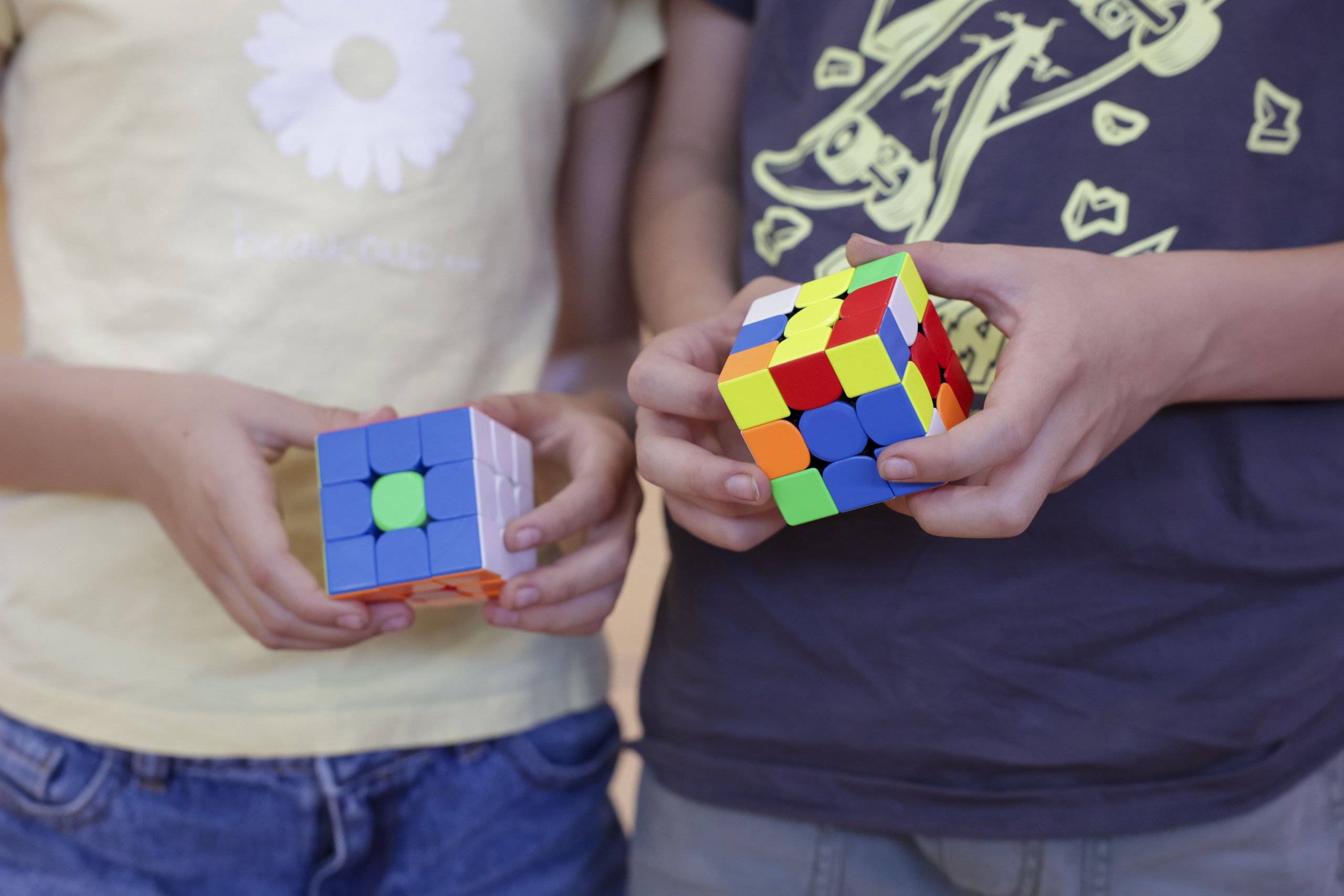 Detalle de las manos de dos niños con sus cubos de Rubik.