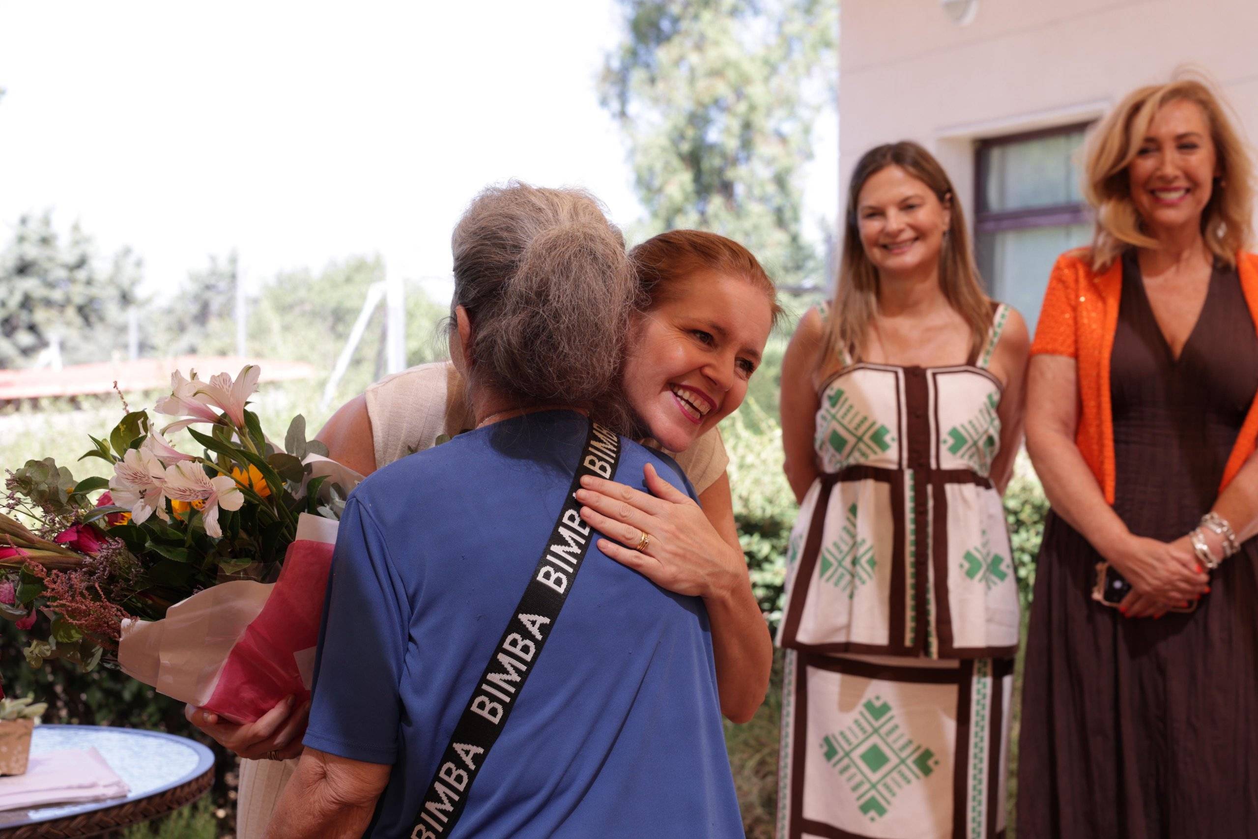 La consejera de Familia, Juventud y Asuntos Sociales, Ana Dávila, saluda a una mujer en presencia de la primera teniente de alcalde de Villanueva de la Cañada y la directora de AMAPAD, Encarna Rivero.