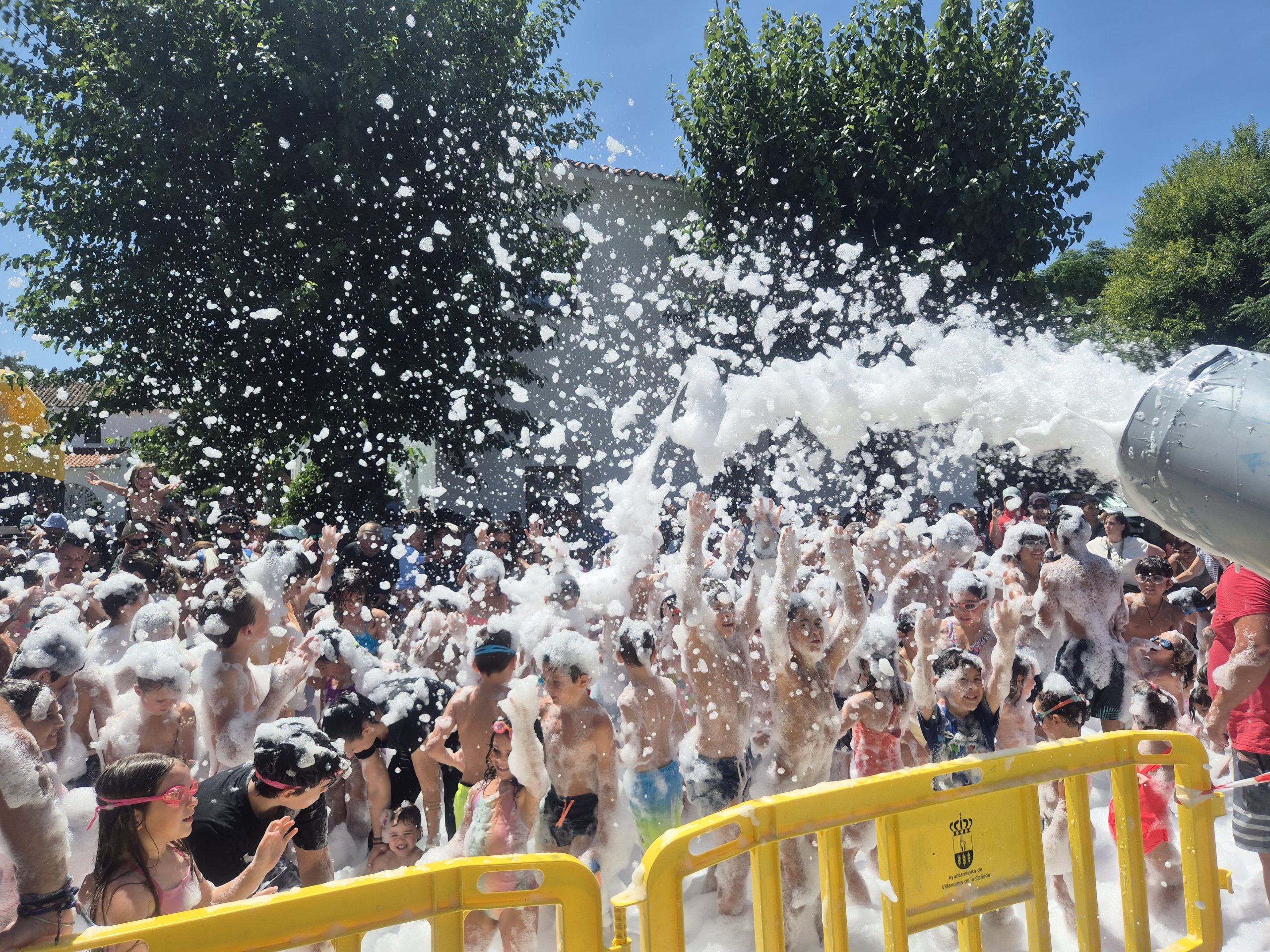 Niños debajo de un cañón de espuma