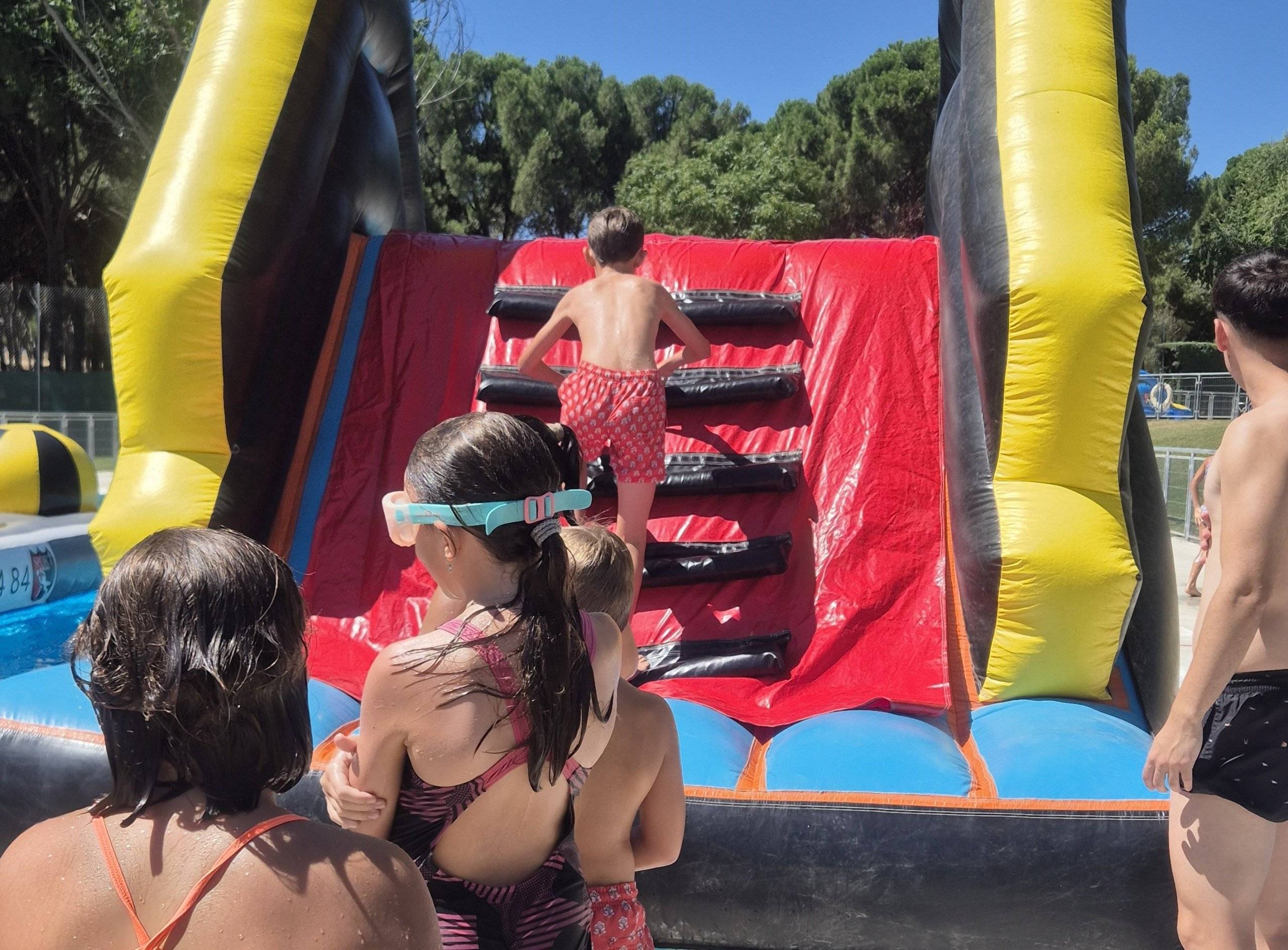 Niño subiendo un castillo hinchable