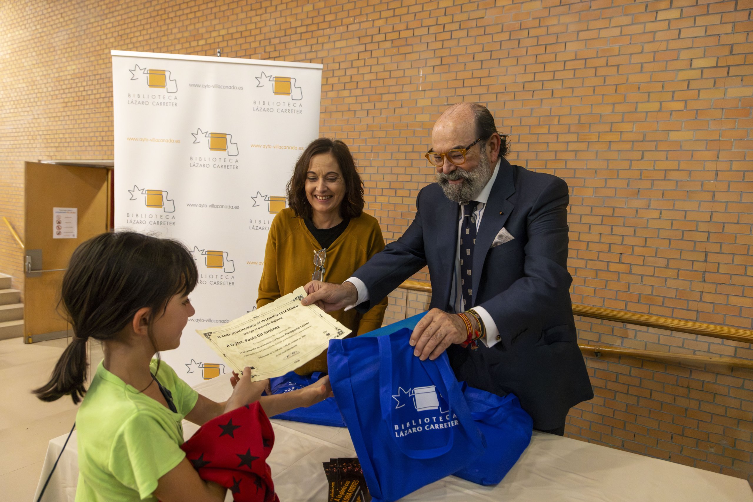 El concejal de Cultura y la directora de la Biblioteca durante la entrega de regalos a los participantes en el "Pasaporte Lector".