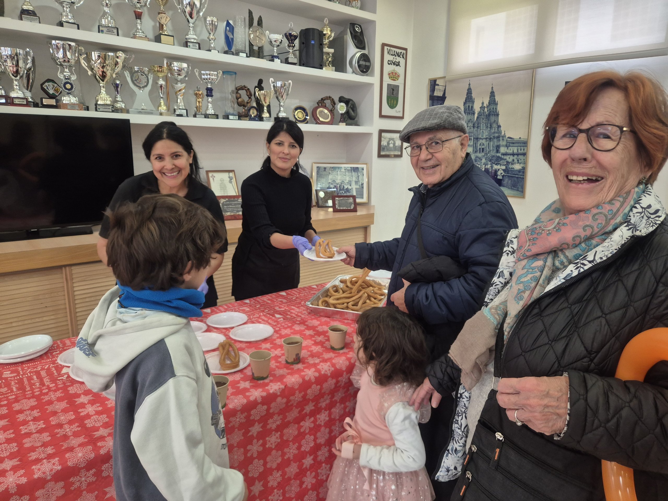 Abuelos acompañados por sus nietos en la chocolatada.