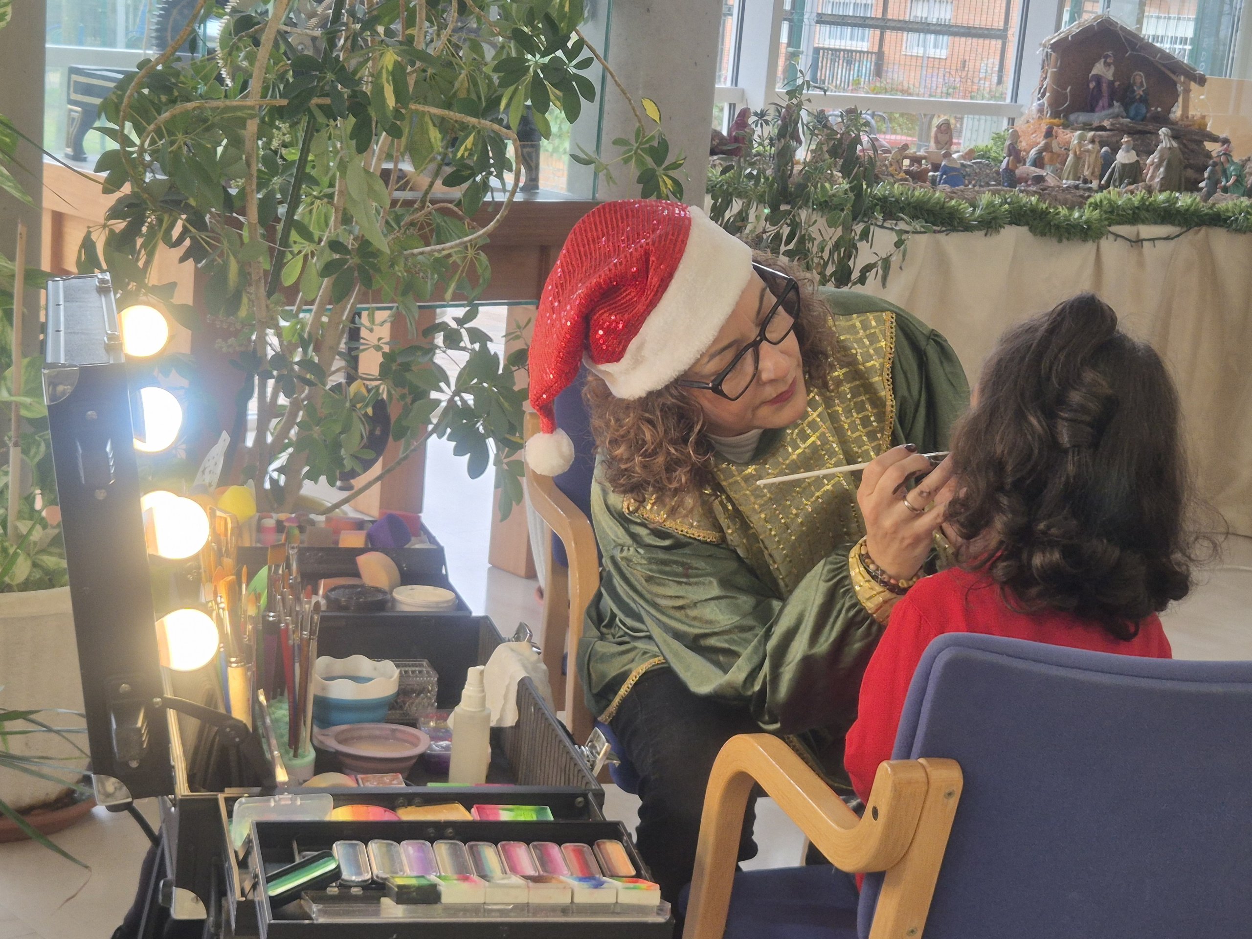 Una maquilladora pintando a un niña.
