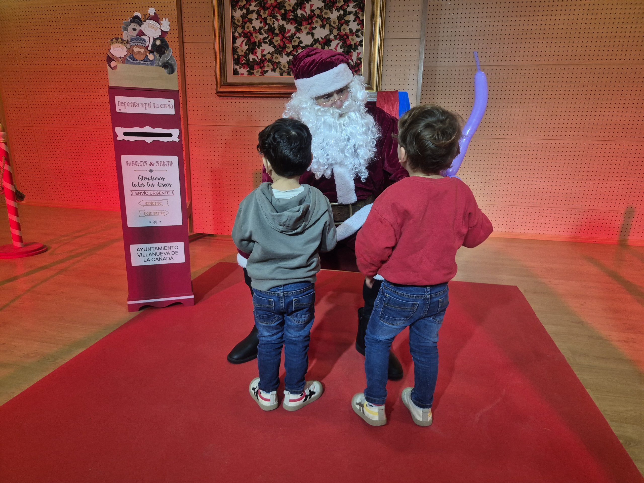 Papá Noel conversando con dos niños.