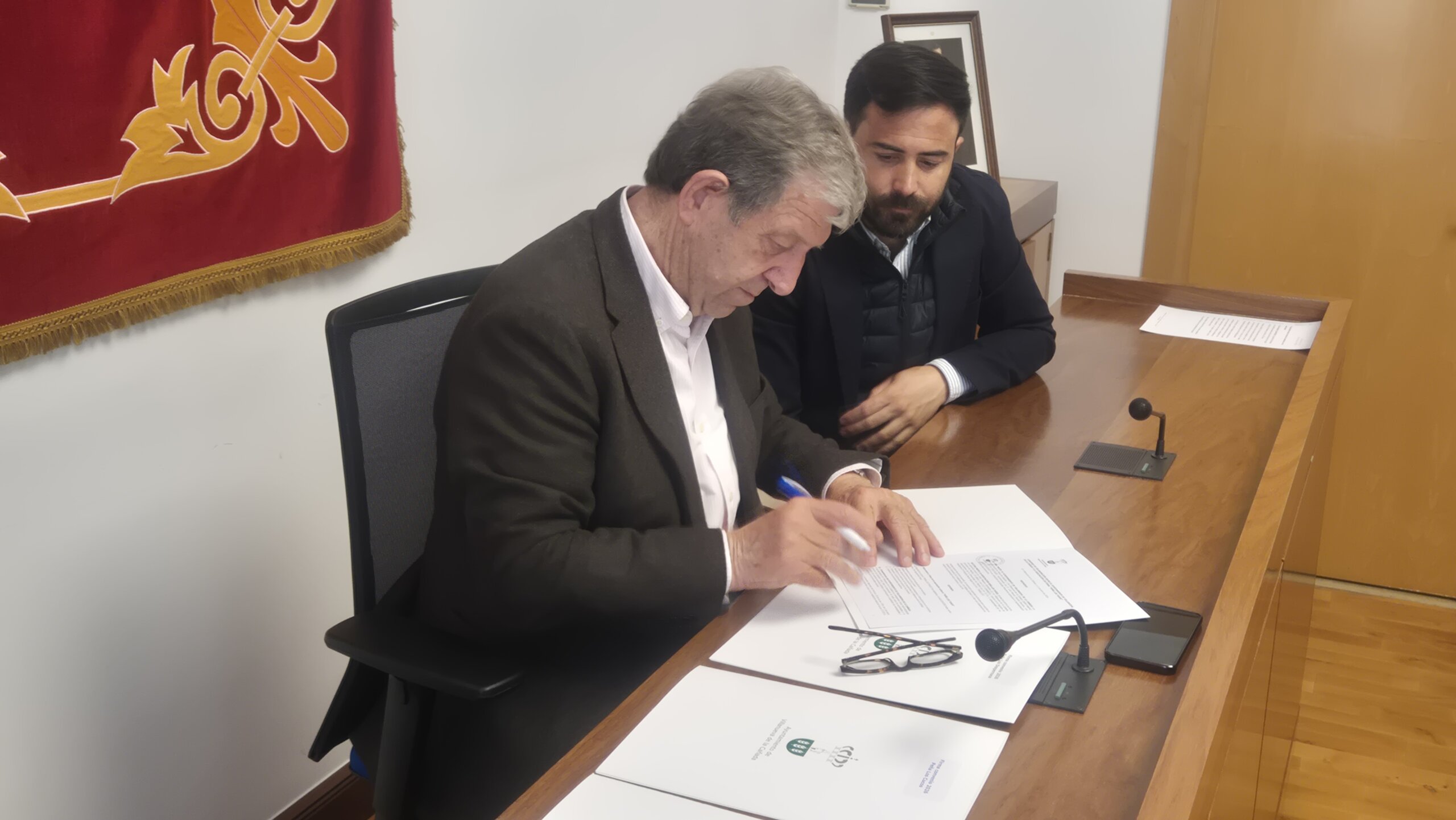 El alcalde y el concejal de festejos durante la firma del convenio.