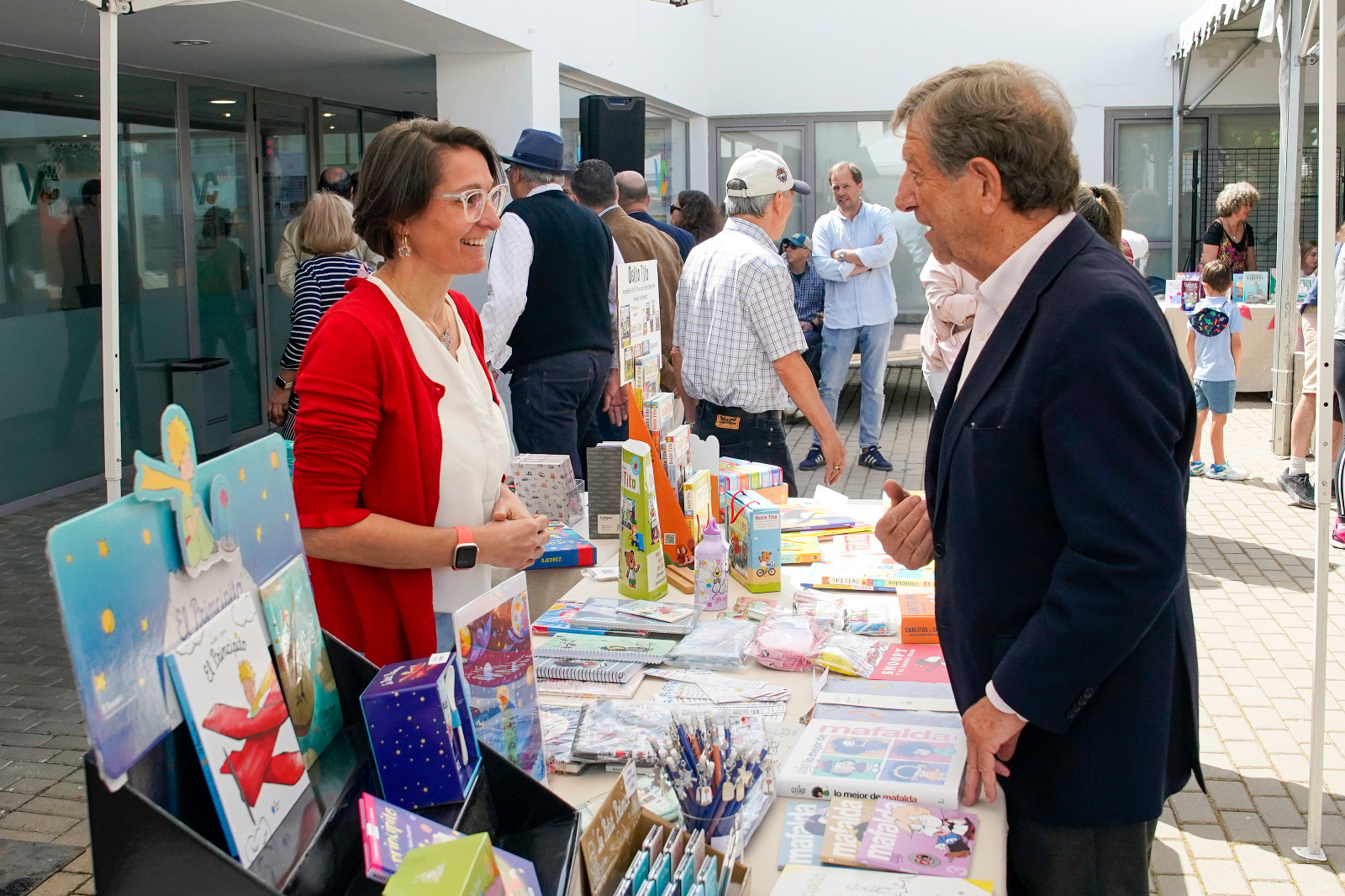 El alcalde saluda a una comerciante local durante el Mercadillo Solidario de Libros.