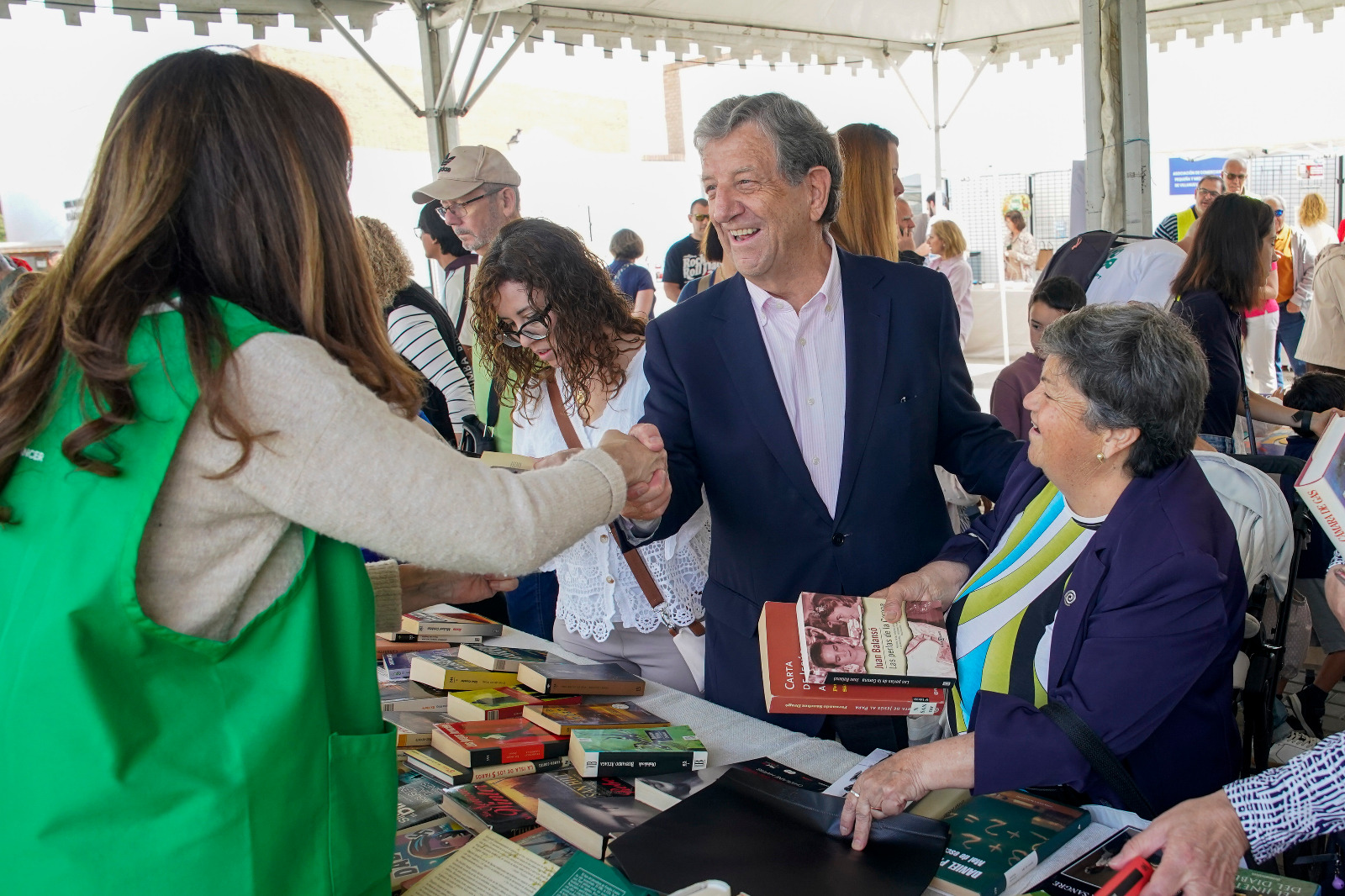 El alcalde saluda a una voluntaria del Mercadillo Solidario de Libros.