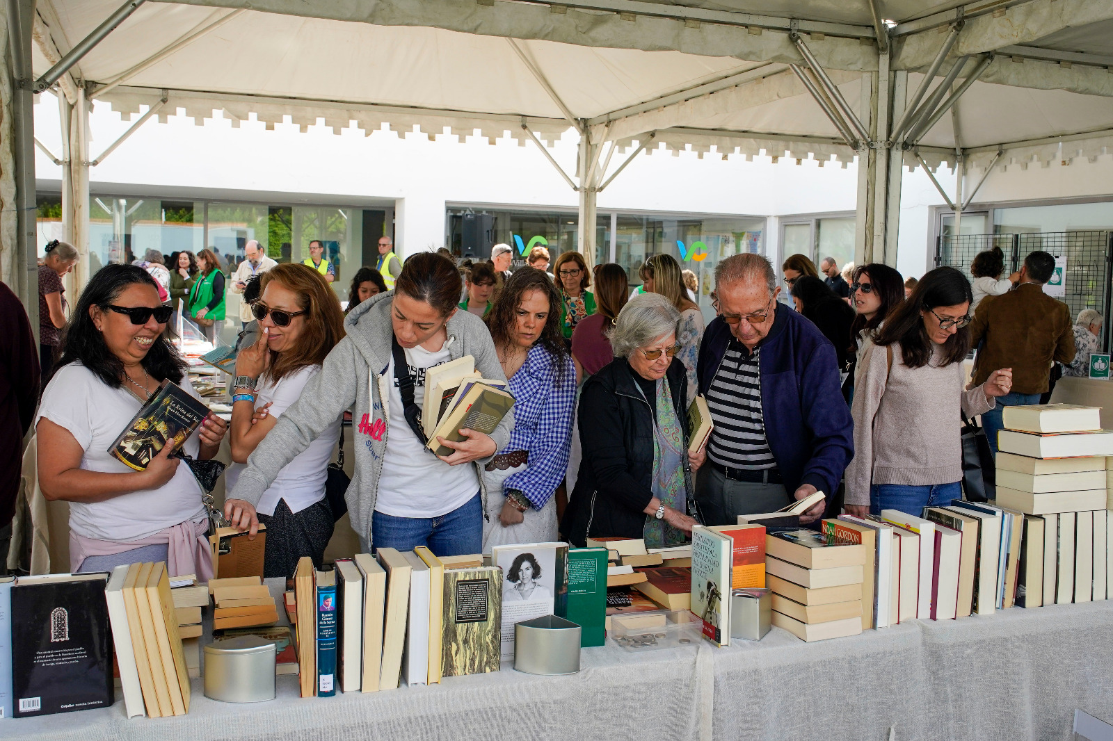Público mirando los ejemplares del Mercadillo Solidario de Libros.