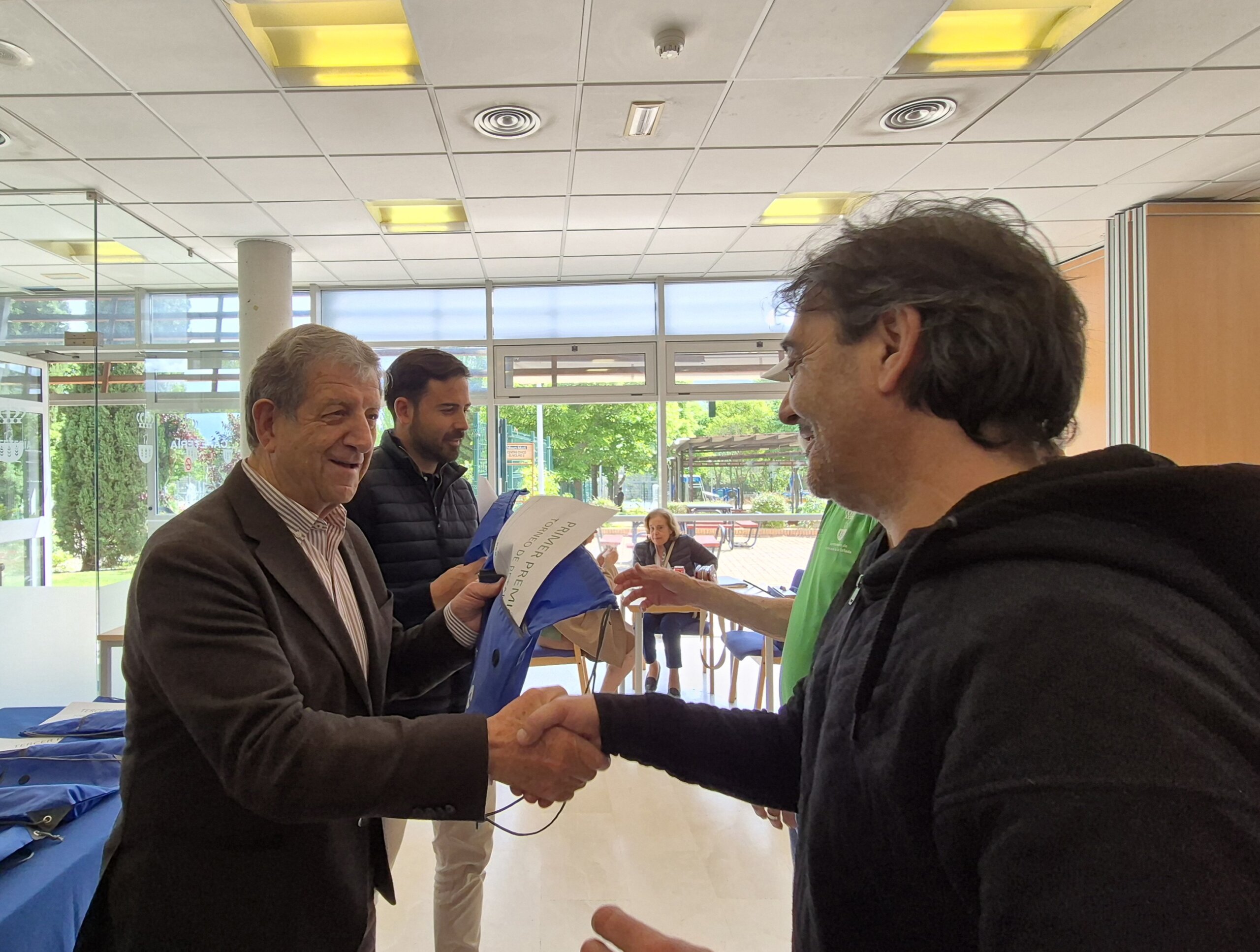El alcalde saluda a uno de los participantes antes de entregarle el obsequio.