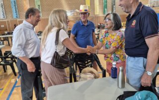 La viceconsejera, junto al alcalde, saludando a las personas alojadas en el pabellón.