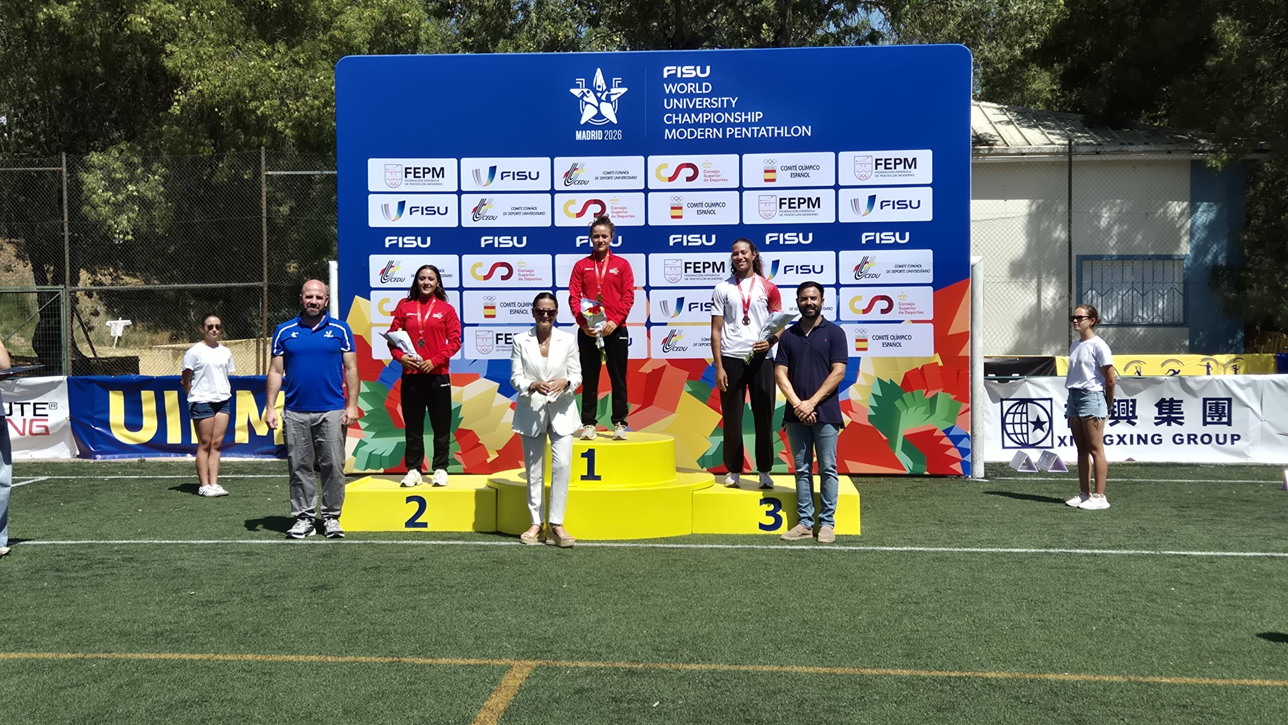 Los responsables de la FISU y de la Federación Española de Pentatlón Moderno, junto al concejal de Deportes del Ayuntamiento de Villanueva de la Cañada, posan con los ganadores de una de las pruebas femeninas.