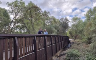 El alcalde, el concejal de Obras y el Jefe de Infraestructuras y Edificación en la pasarela sobre el río Aulencia.