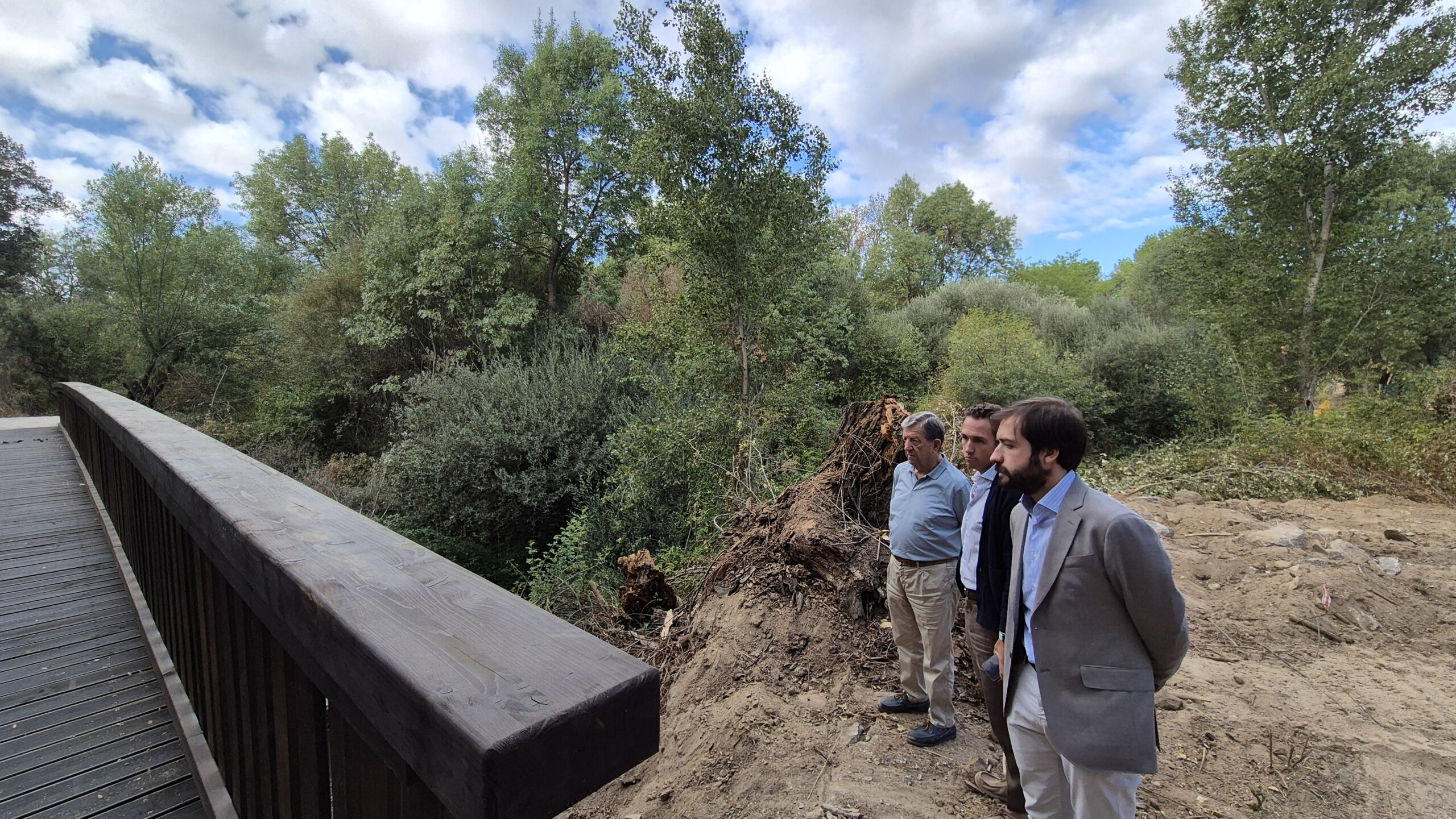 El alcalde, el concejal de Obras y el Jefe de Infraestructuras y Edificación observan la pasarela sobre el río Aulencia.