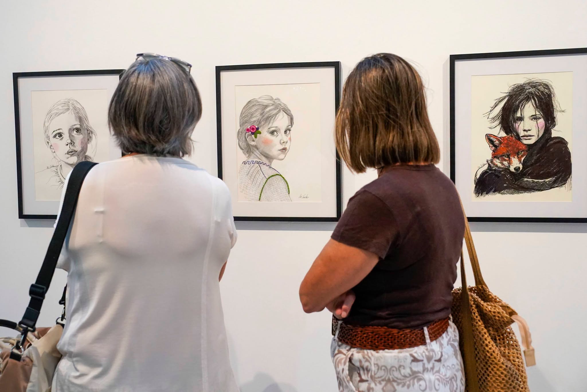 Público visitando la muestra "Retratos ilustrados" de Velo de Tinta.
