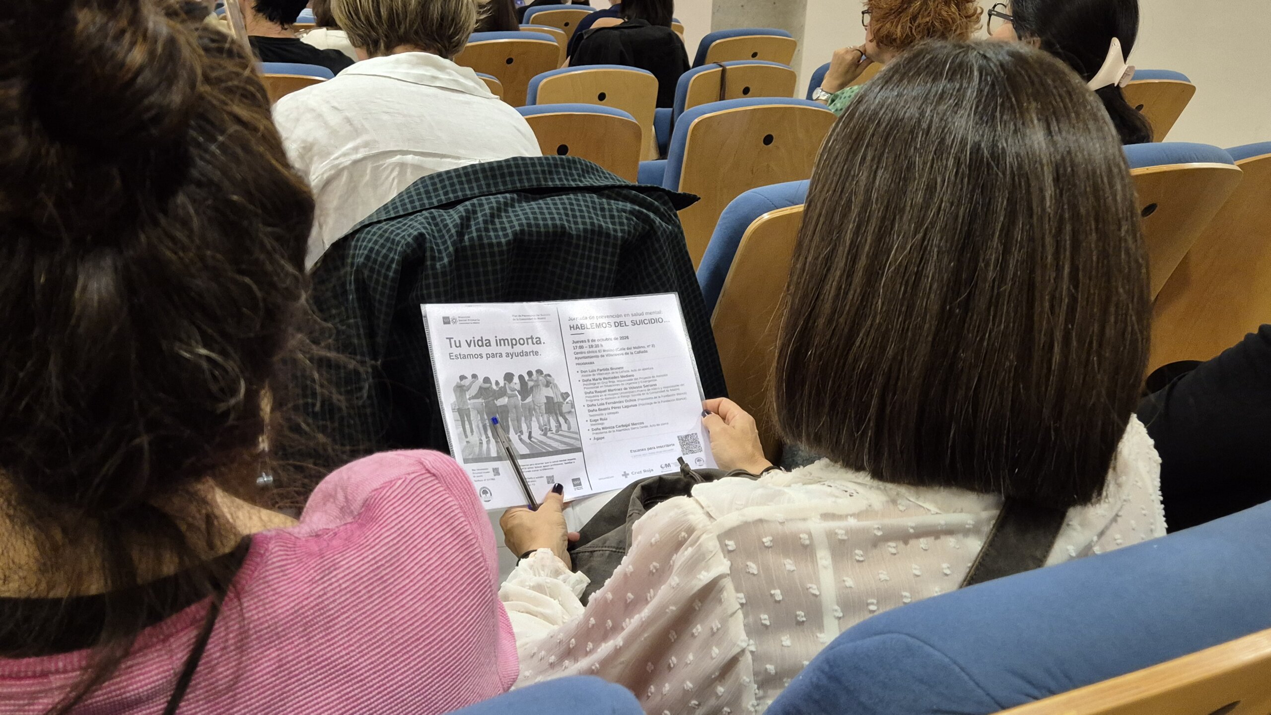 Asistente a la ponencia con el programa de mano.