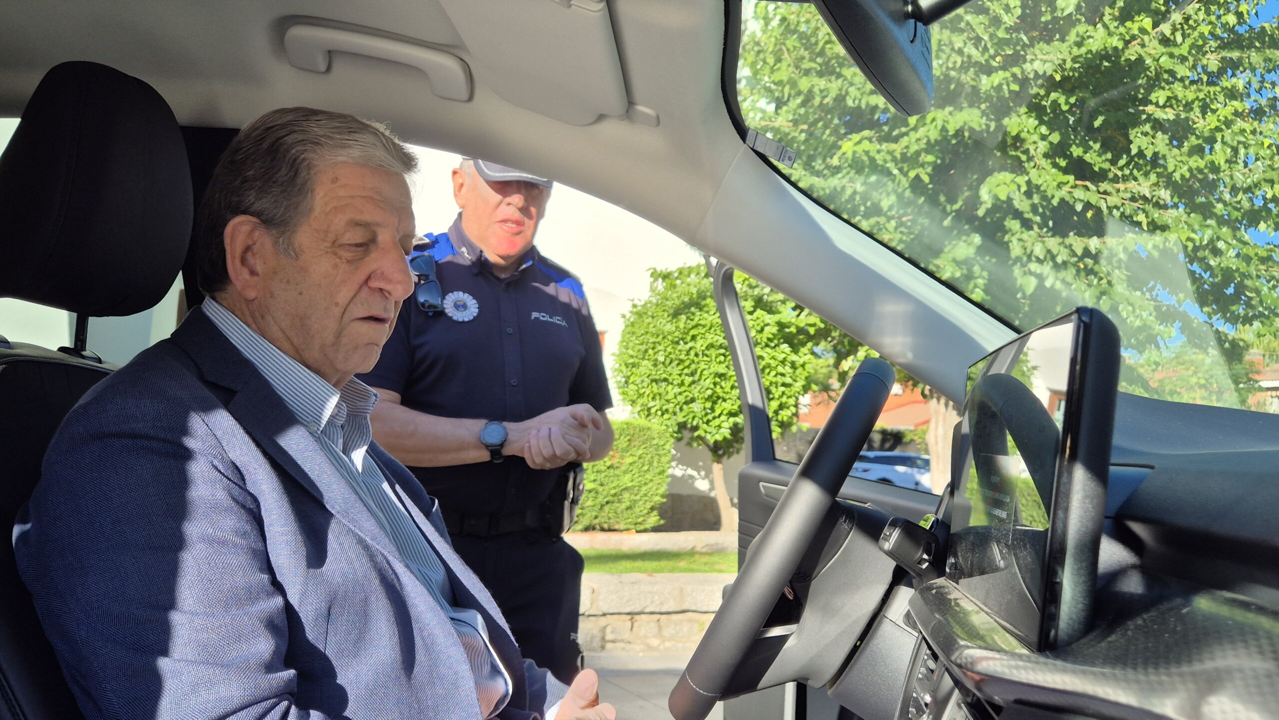 El alcalde, en el interior del vehículo, habla con el jefe de Policía Local.
