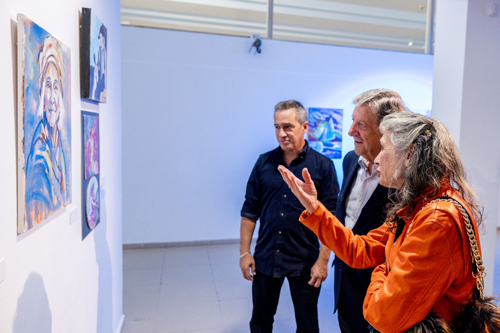 El alcalde observa un cuadro junto a la artista y el profesor de la Escuela de Pintura de Mayores.